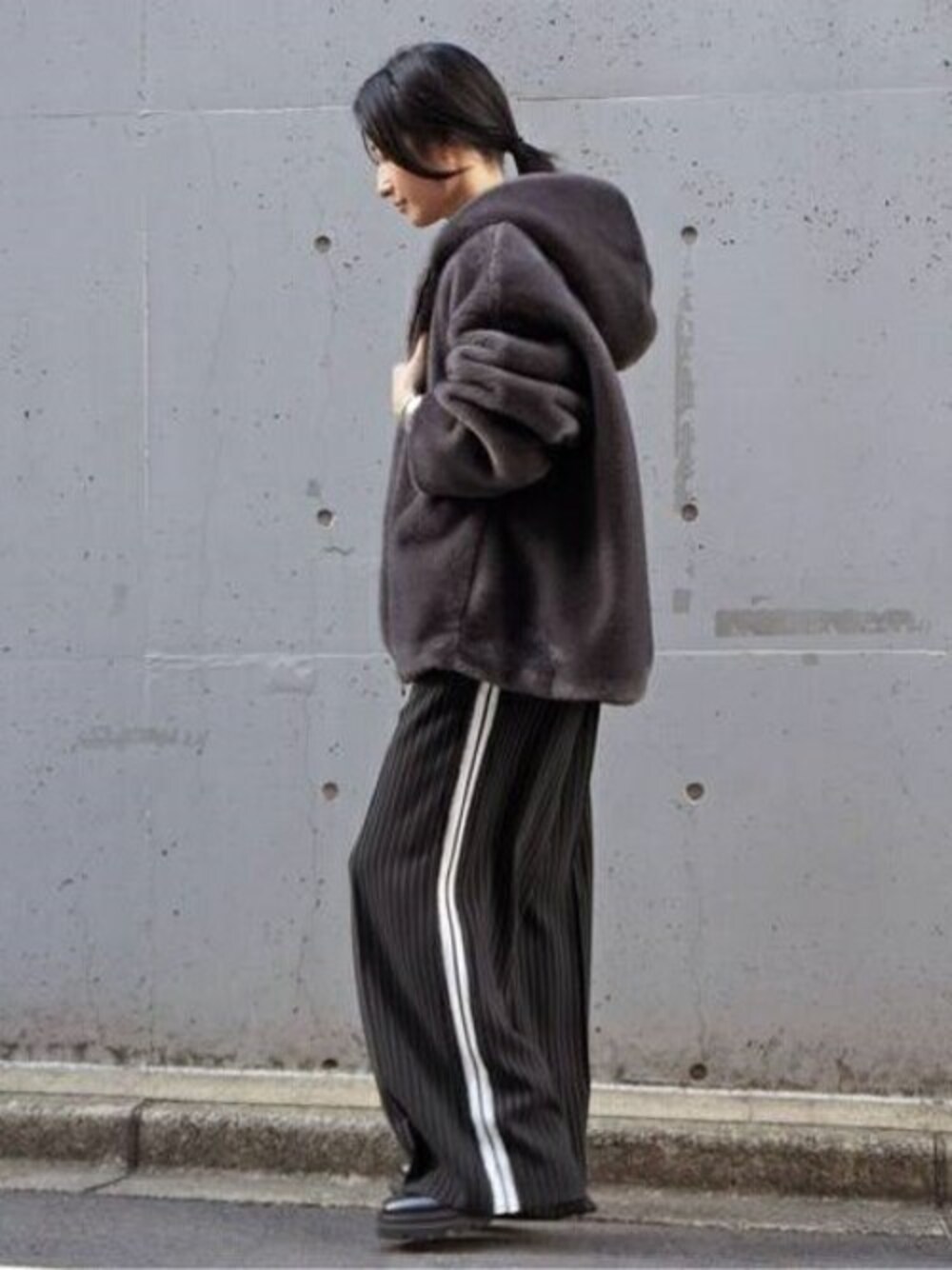 グレー系のブルゾン、ブラック系のスラックスを着用したレディースの秋コーディネートの1枚目の写真