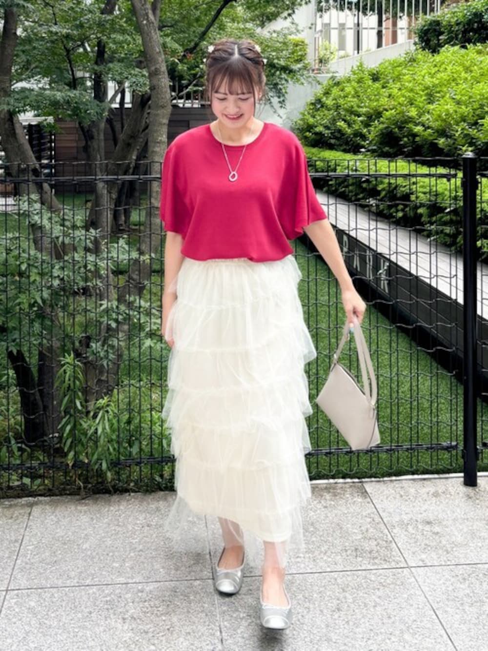 レッド系のニット/セーター、グレー系のショルダーバッグ、シルバー系のネックレスを着用したレディースの夏コーディネートの1枚目の写真