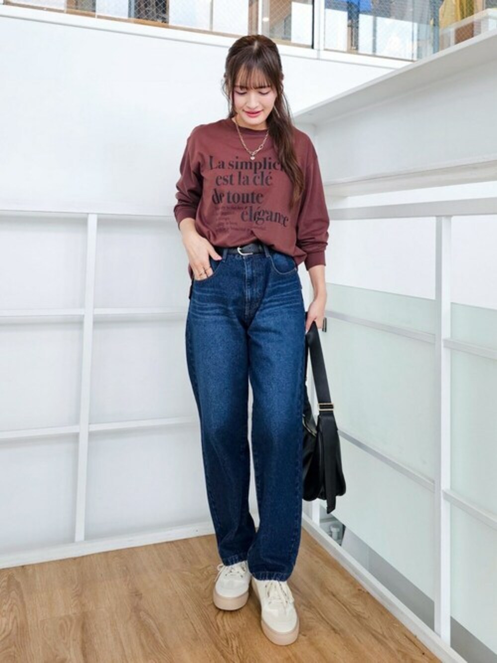 ベージュ系のスニーカー、ブルー系のデニムパンツを着用したレディースの秋コーディネートの1枚目の写真