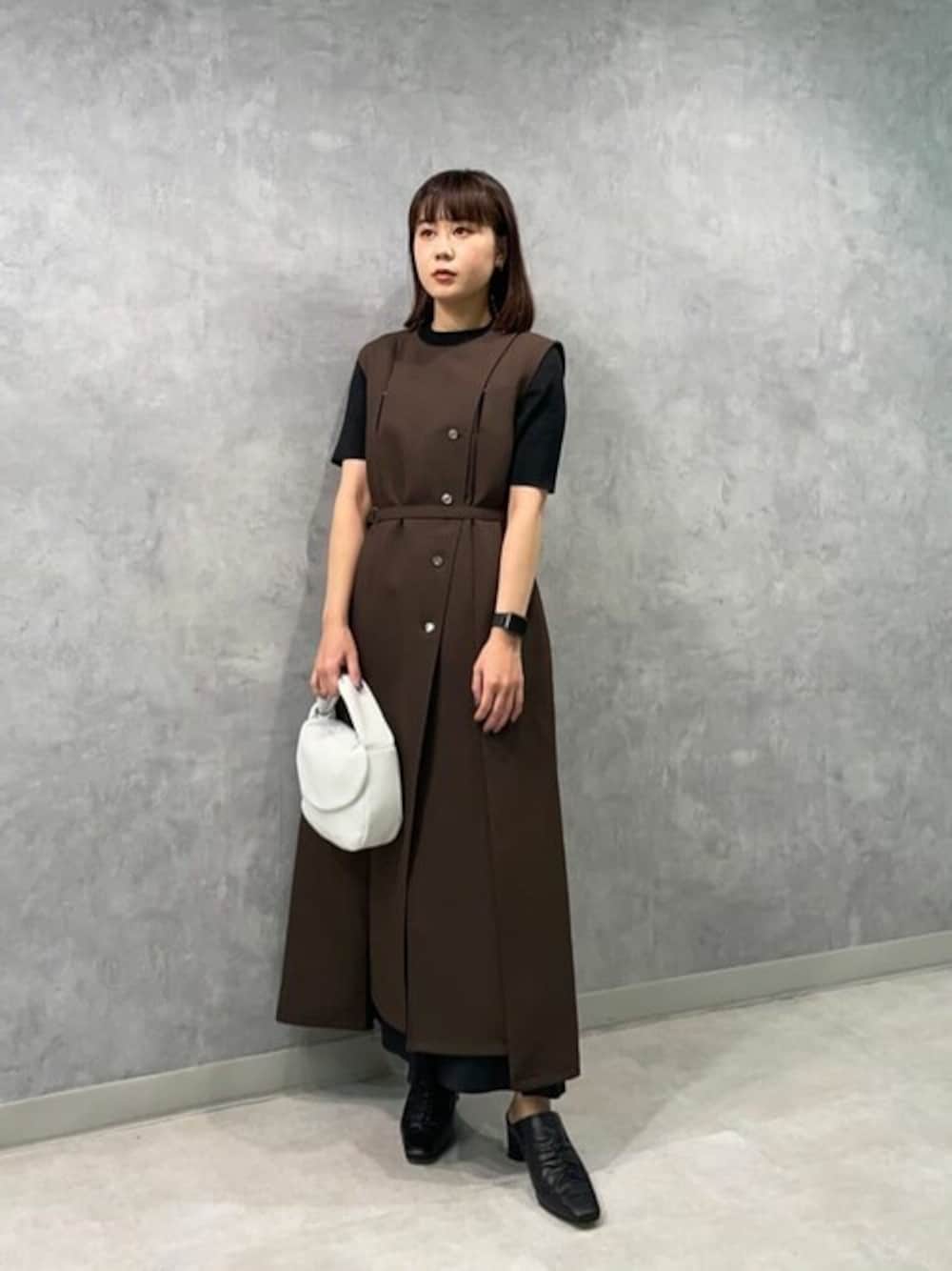 ブラウン系のベスト、ブラック系のニット/セーター、ブラック系のスカートを着用したレディースの夏コーディネートの1枚目の写真