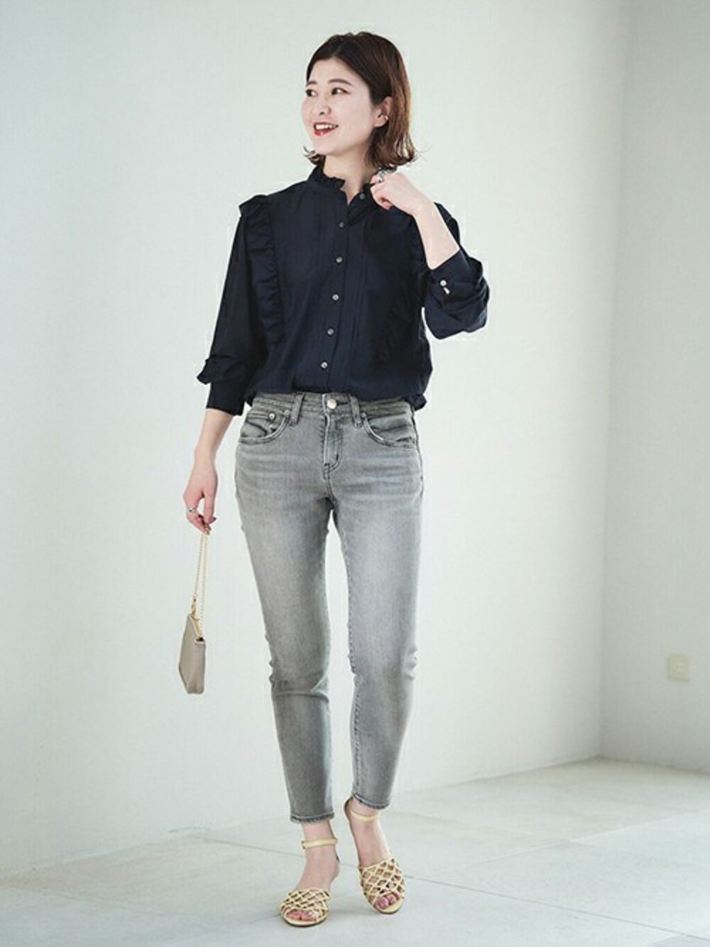 ベージュ系のデニムパンツ、ブルー系のシャツ/ブラウス、グレー系のハンドバッグを着用したレディースの冬コーディネートの1枚目の写真