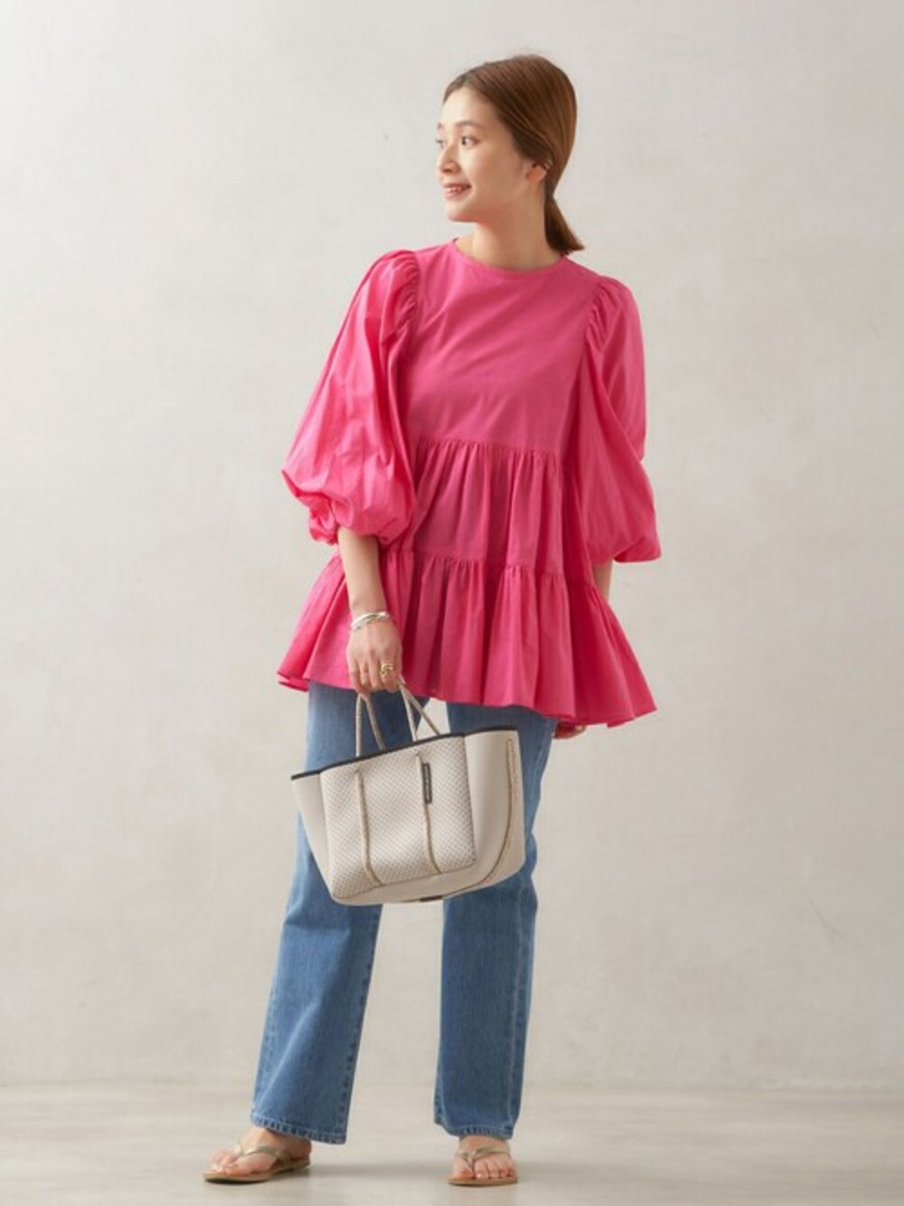 ピンク系のシャツ/ブラウス、ブルー系のデニムパンツを着用したレディースの春コーディネートの1枚目の写真