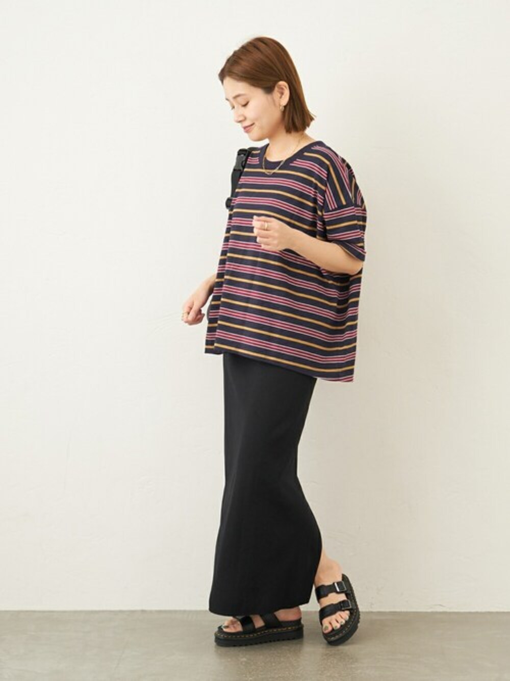 ブルー系のTシャツ/カットソー、ブラック系のスカート、ブラック系のショルダーバッグを着用したレディースの春コーディネートの1枚目の写真