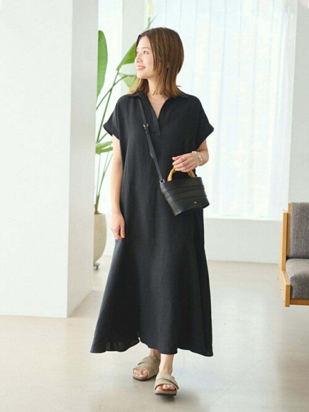 ブラック系のワンピース、ベージュ系のサンダルを着用したレディースの夏コーディネートの1枚目の写真