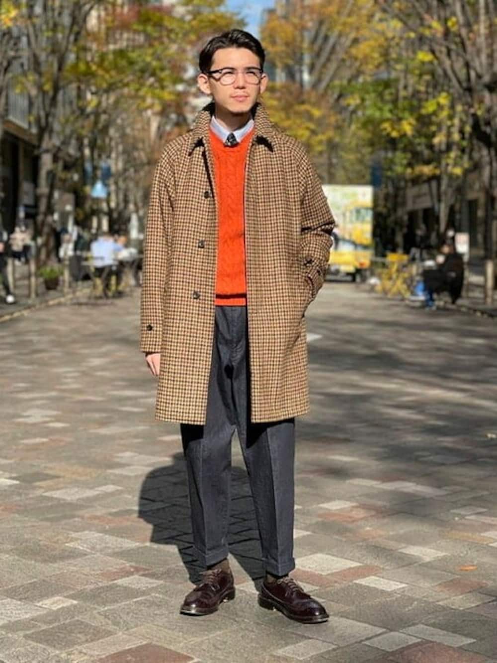オレンジ系のニット/セーター、ブルー系のデニムパンツ、その他のその他アウターを着用したメンズの冬コーディネートの1枚目の写真