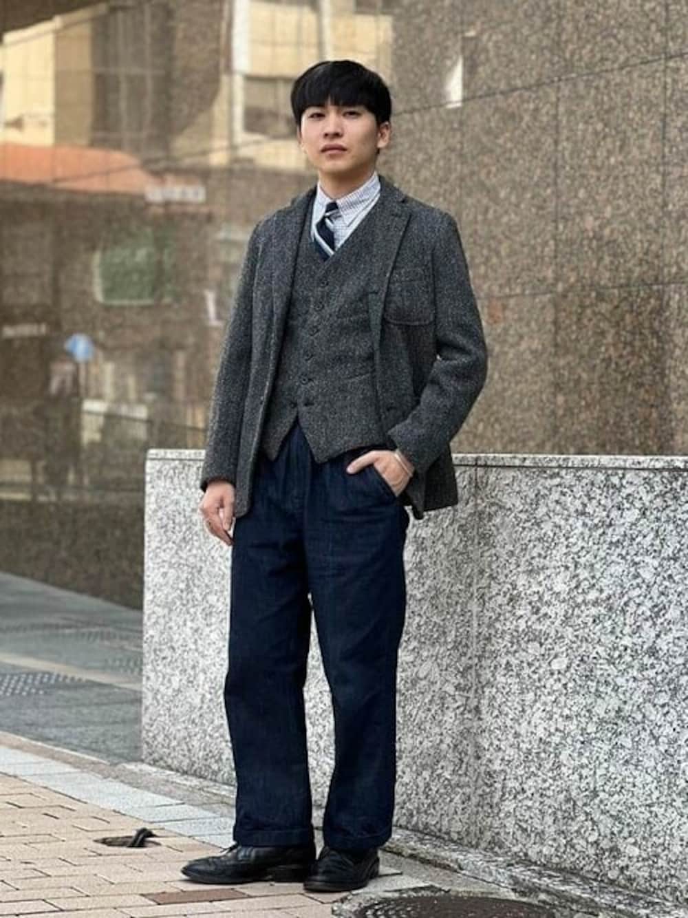 グレー系のテーラードジャケット、グレー系のベストを着用したメンズの冬コーディネートの1枚目の写真