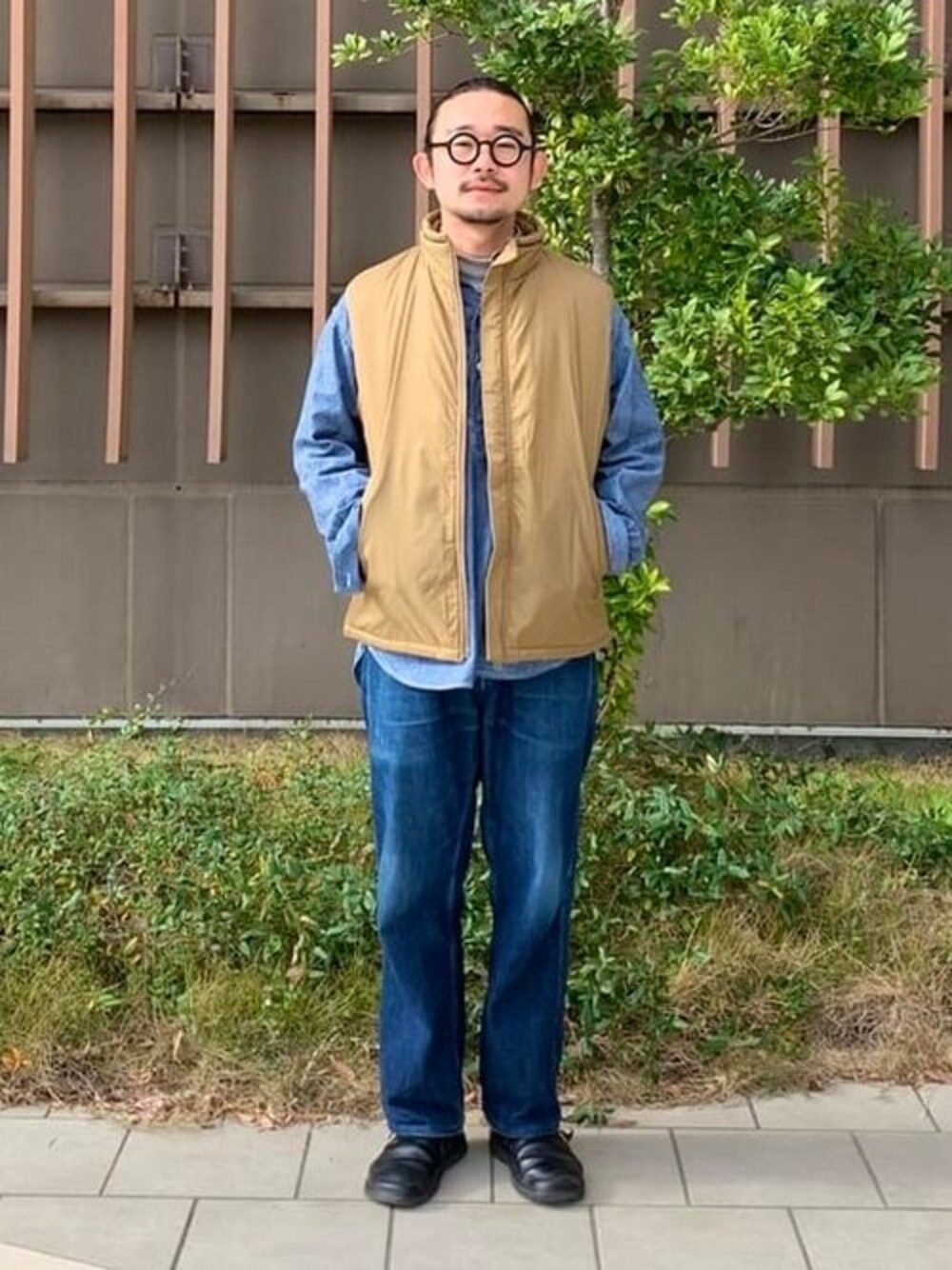 グリーン系のベストを着用したメンズの冬コーディネートの1枚目の写真