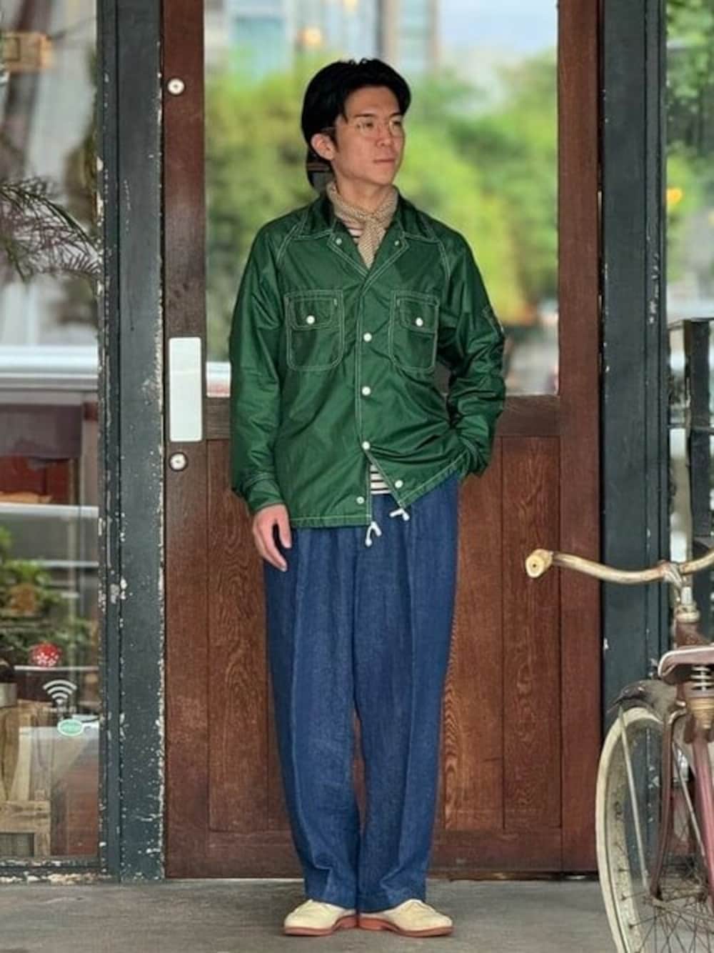 グリーン系のブルゾン、ブルー系のデニムパンツを着用したメンズの春コーディネートの1枚目の写真