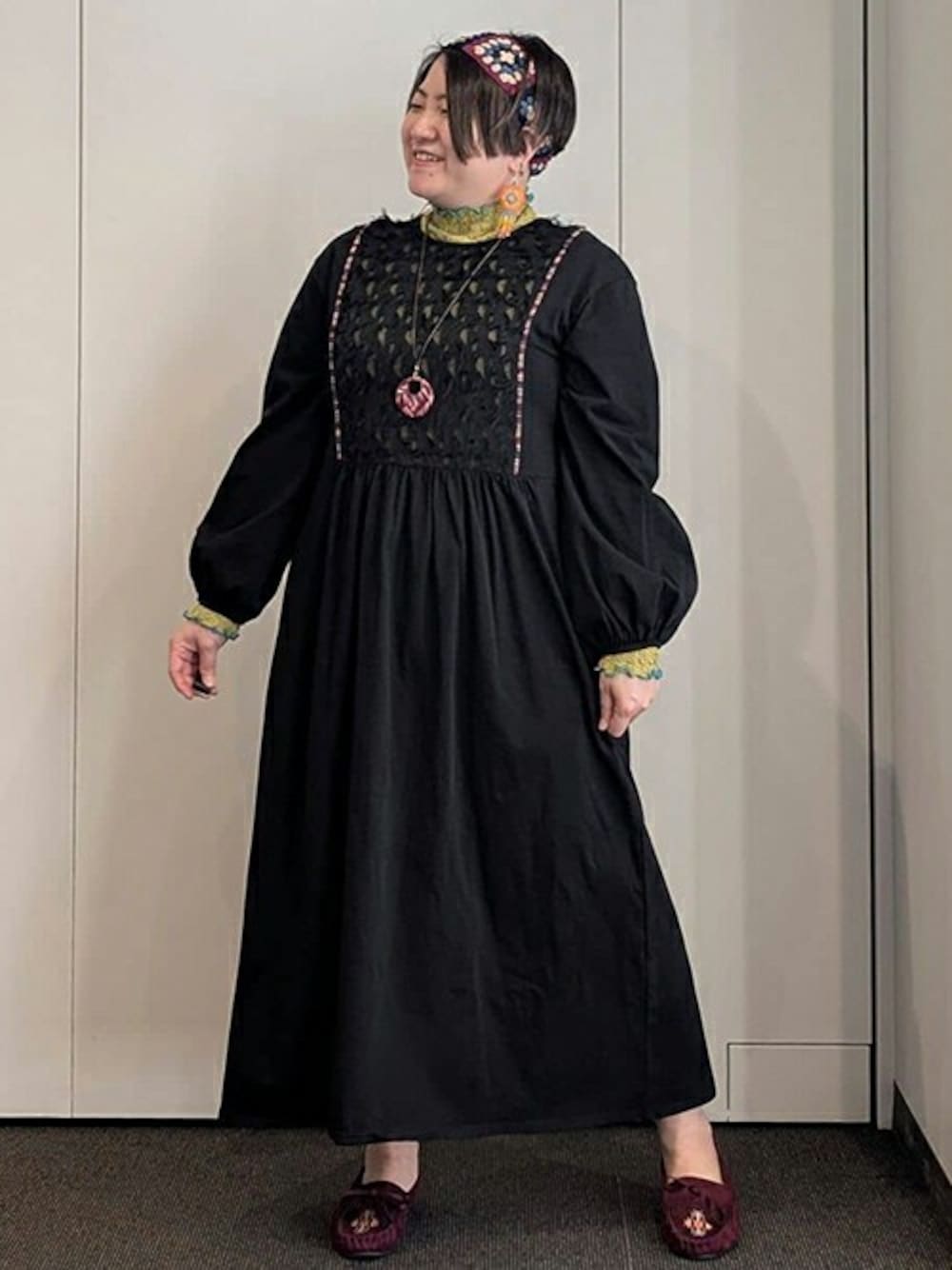 ブラック系のワンピース、グリーン系のTシャツ/カットソー、ブルー系のヘアバンドを着用したレディースの冬コーディネートの1枚目の写真