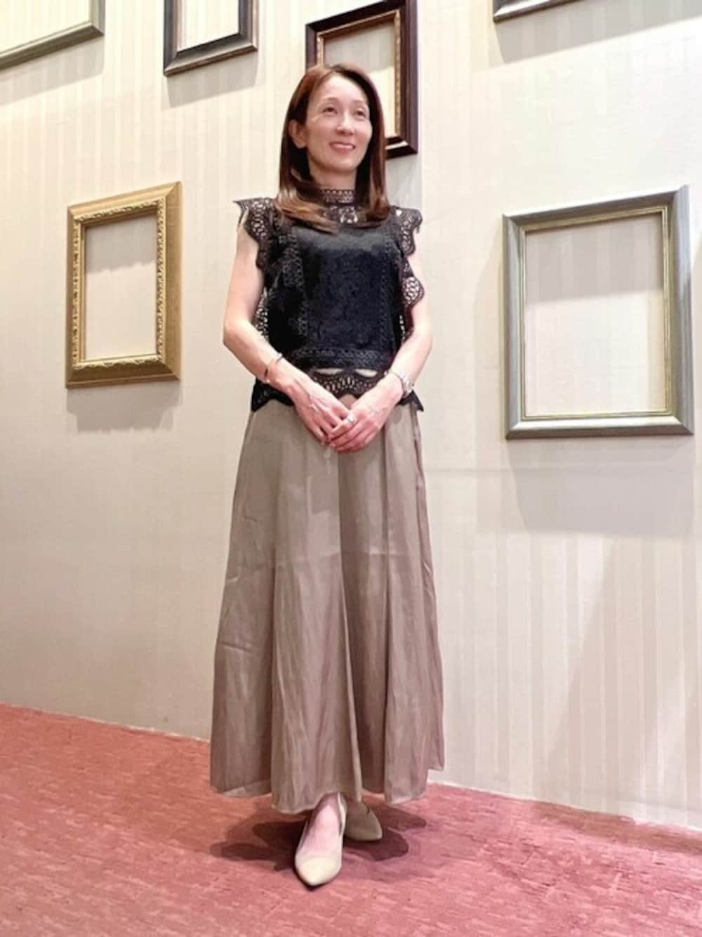 ベージュ系のスカートを着用したレディースの夏コーディネートの1枚目の写真