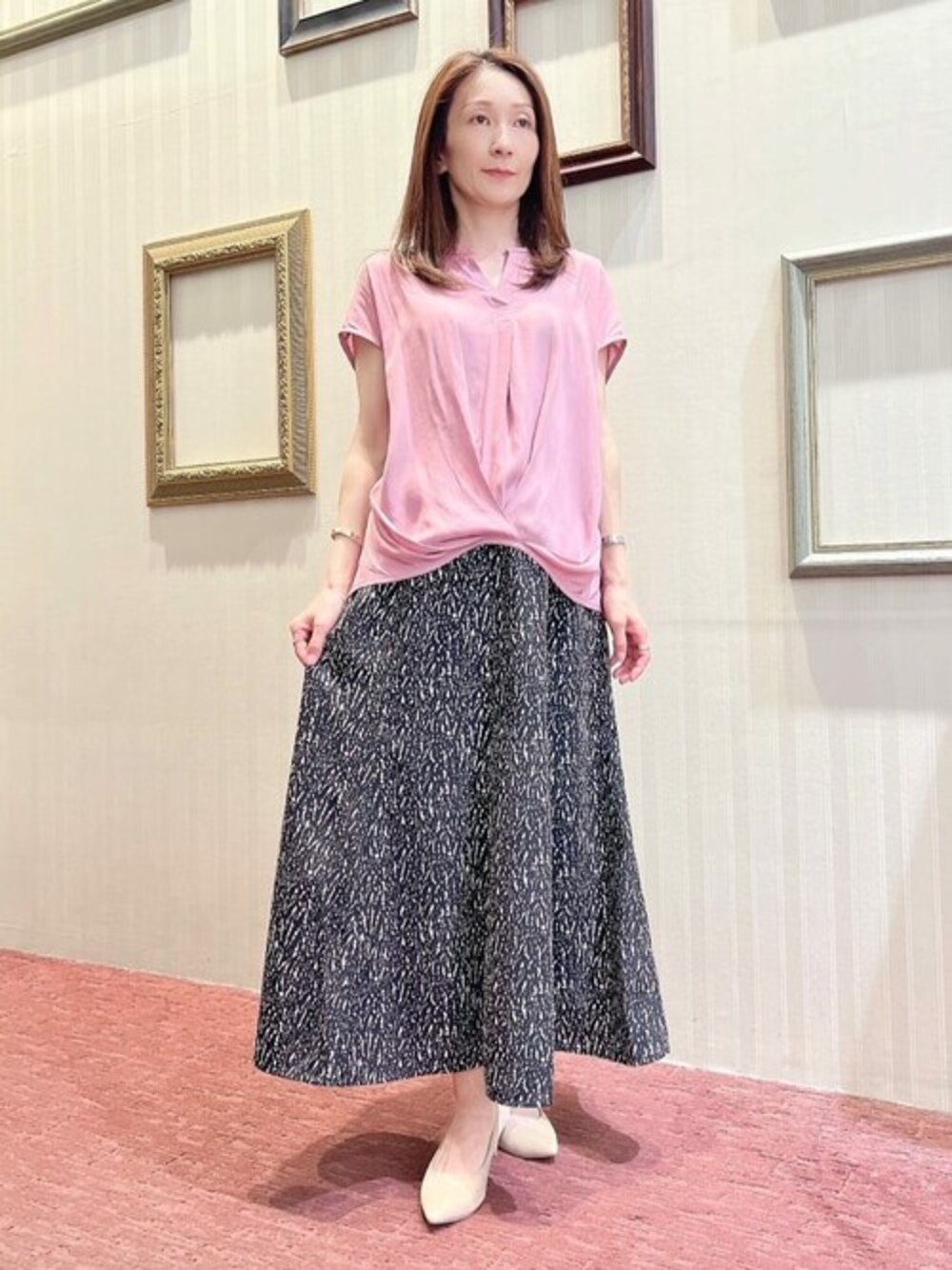 ピンク系のTシャツ/カットソー、ブラック系のスカートを着用したレディースの夏コーディネートの1枚目の写真