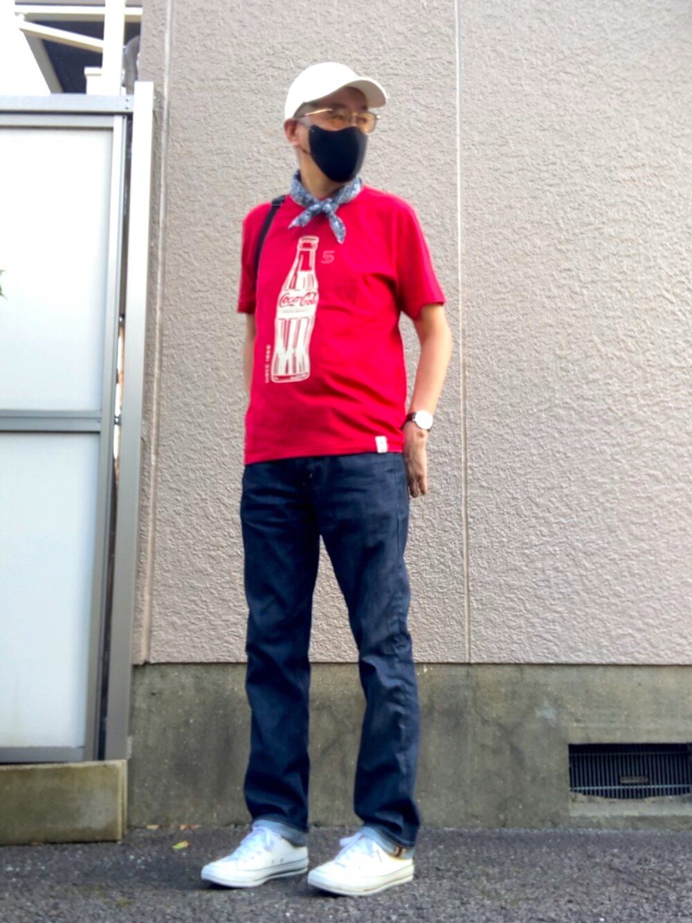 レッド系のTシャツ/カットソー、ブルー系のデニムパンツ、ホワイト系のスニーカーを着用したメンズの夏コーディネートの1枚目の写真