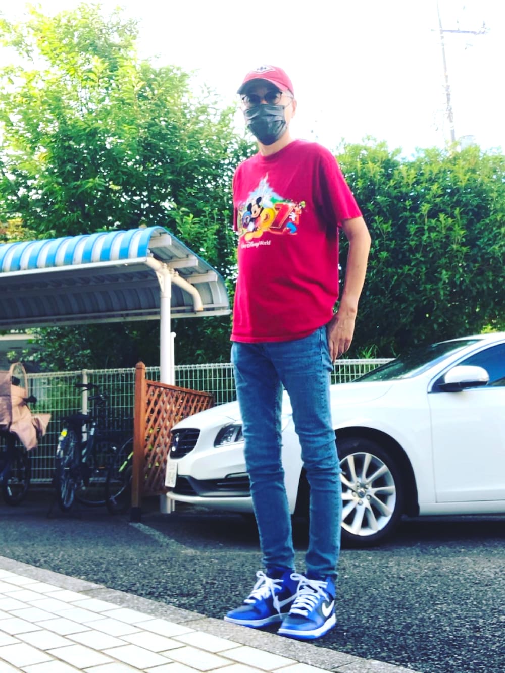 レッド系のTシャツ/カットソー、ブルー系のデニムパンツ、ブルー系のスニーカーを着用したメンズの夏コーディネートの1枚目の写真