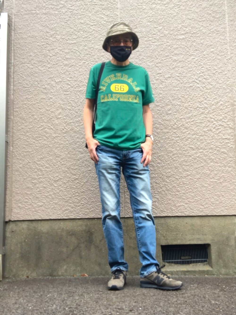 グリーン系のTシャツ/カットソー、ブルー系のデニムパンツ、ブラック系のスニーカーを着用したメンズの夏コーディネートの1枚目の写真