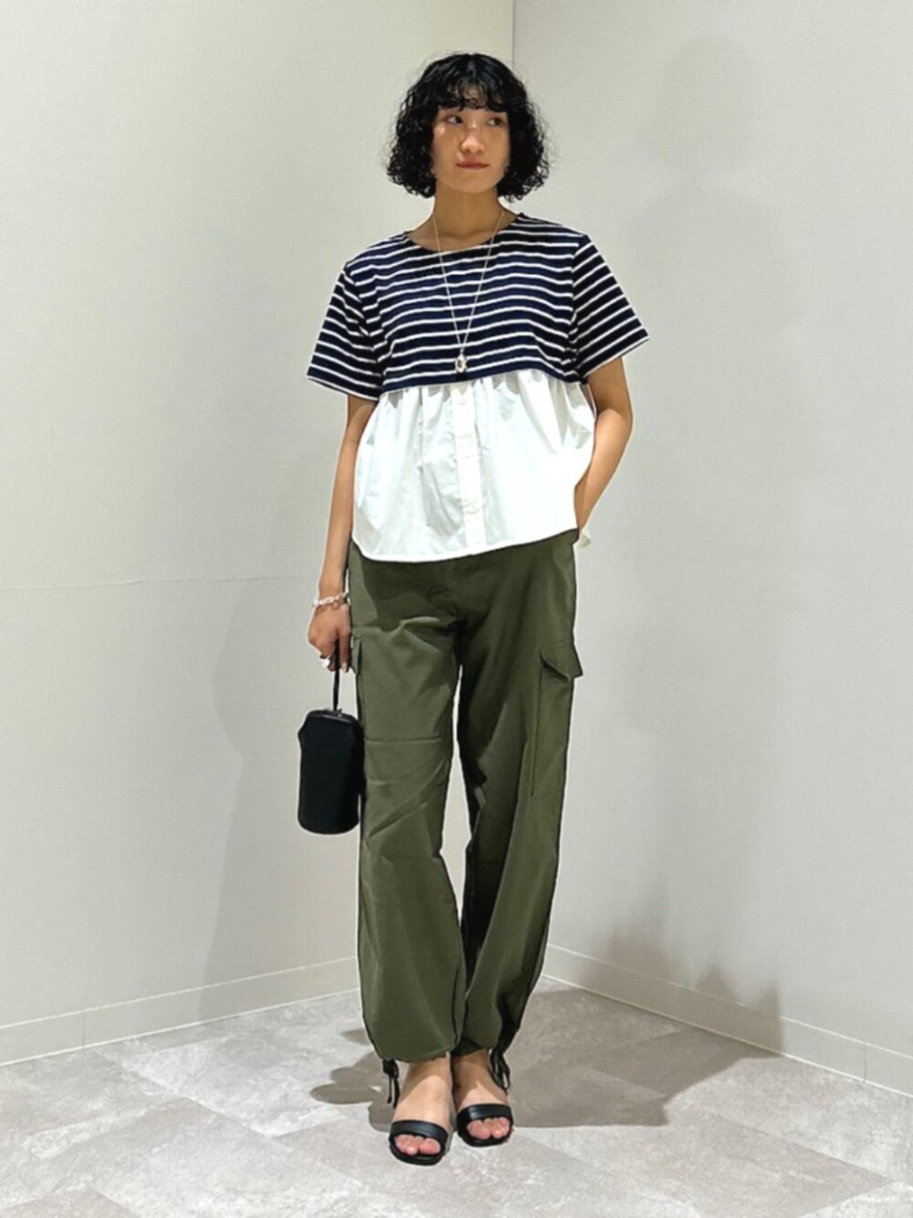 ブラック系のサンダル、グリーン系のカーゴパンツ、ブルー系のTシャツ/カットソーを着用したレディースの夏コーディネートの1枚目の写真