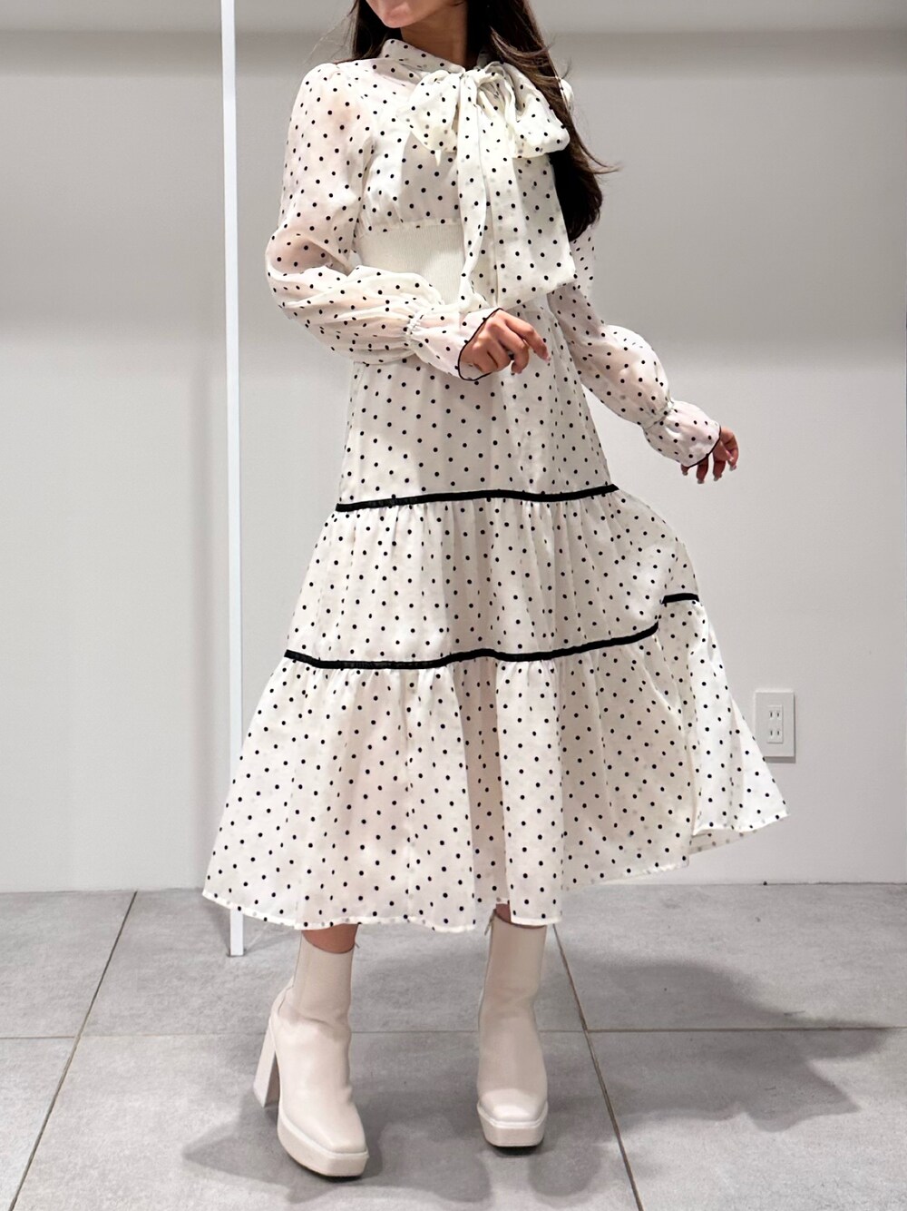 ホワイト系のブーツ、ホワイト系のワンピースを着用したレディースの冬コーディネートの1枚目の写真