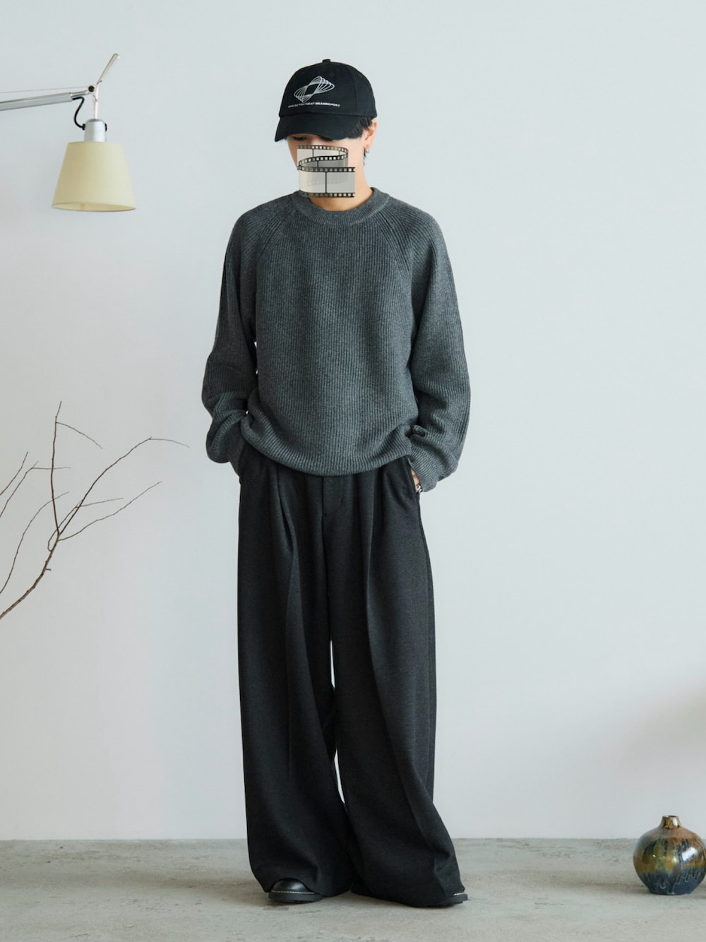 グレー系のスラックス、ブラック系のドレスシューズ、グレー系のニット/セーターを着用したメンズの秋コーディネートの1枚目の写真