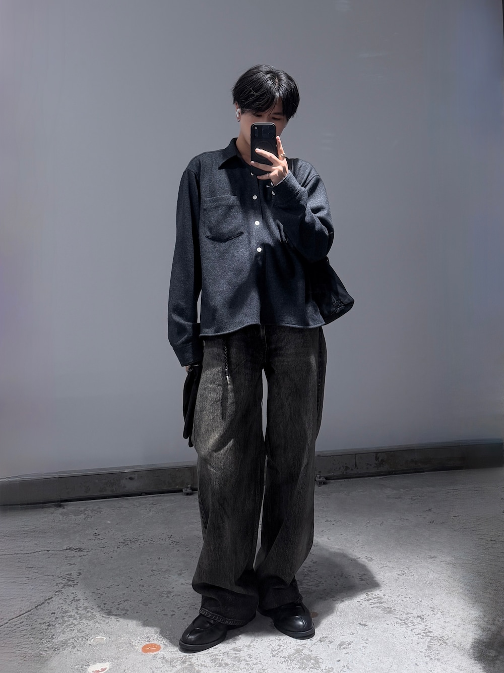 ブラック系のデニムパンツ、ブラック系のシューズ、グレー系のシャツ/ブラウスを着用したメンズの秋コーディネートの1枚目の写真