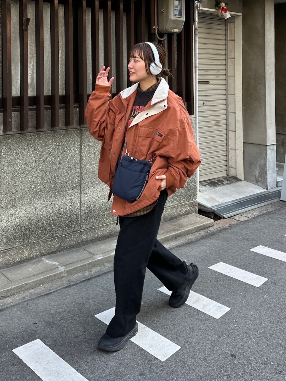 ブラック系のその他パンツ、オレンジ系のマウンテンパーカー、ブルー系のショルダーバッグを着用したレディースの冬コーディネートの1枚目の写真