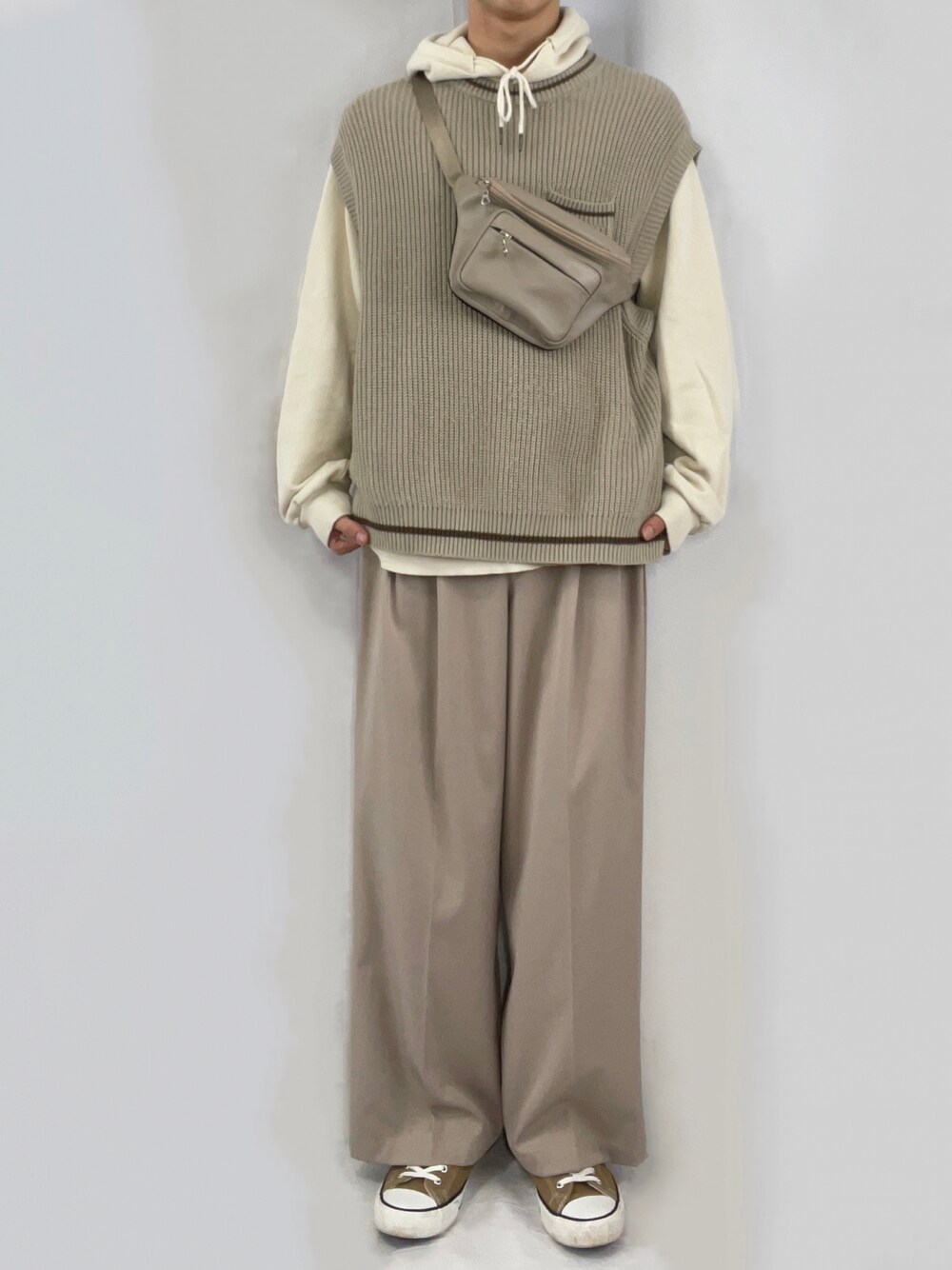 ベージュ系のパーカー、ベージュ系のベスト、ベージュ系のスラックスを着用したメンズの秋コーディネートの1枚目の写真