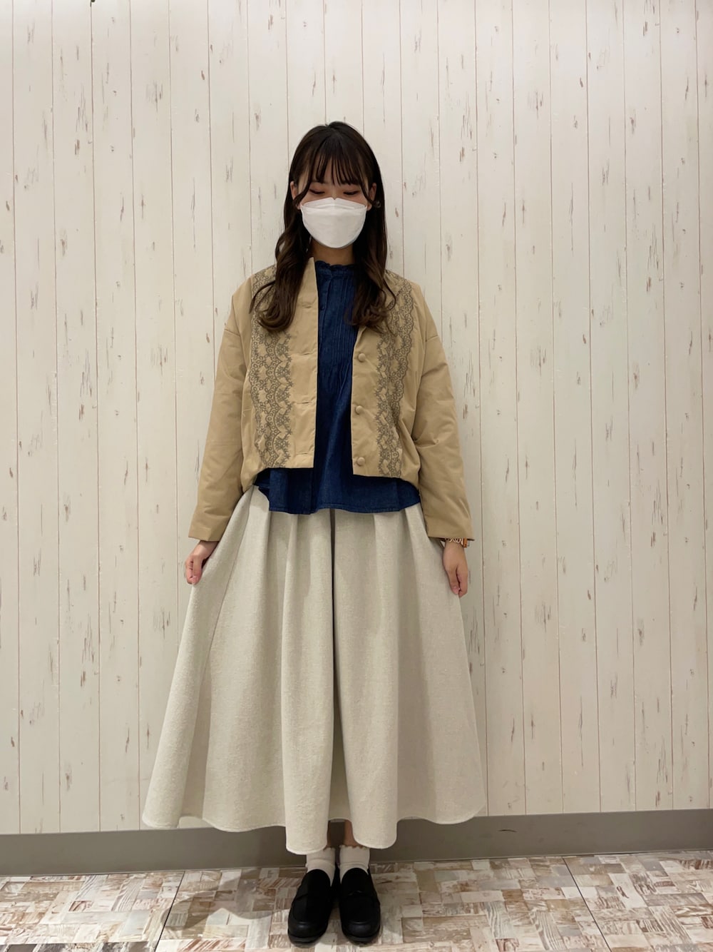 ブルー系のシャツ/ブラウス、ベージュ系のスカート、ブラック系のローファーを着用したレディースの冬コーディネートの1枚目の写真
