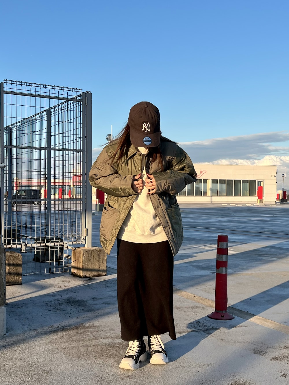 ベージュ系のスウェット、グリーン系のカバーオールを着用したレディースの秋コーディネートの1枚目の写真