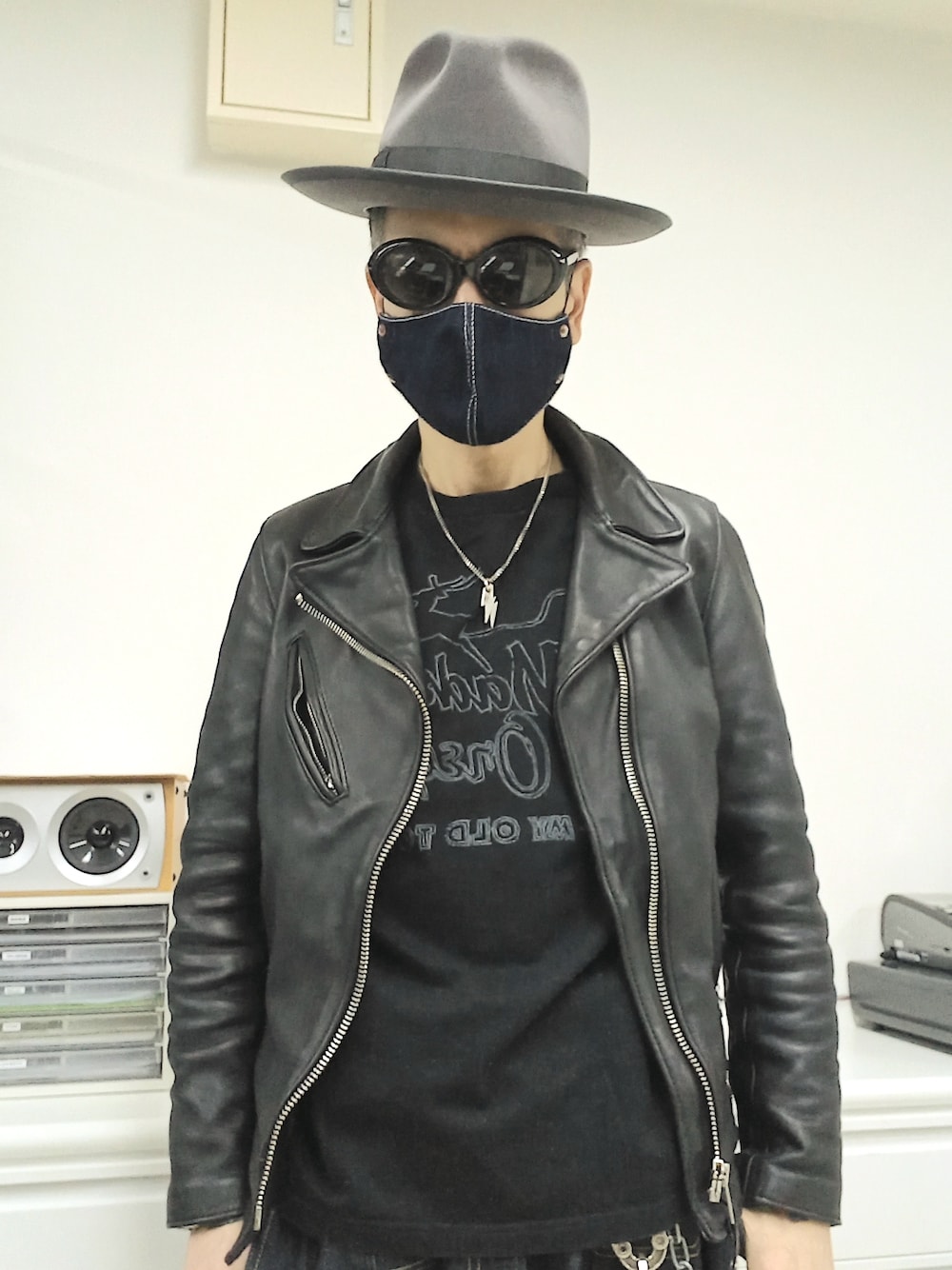 ブルー系のデニムパンツ、ブラック系のTシャツ/カットソー、ブラック系のライダースジャケットを着用したメンズの春コーディネートの2枚目の写真