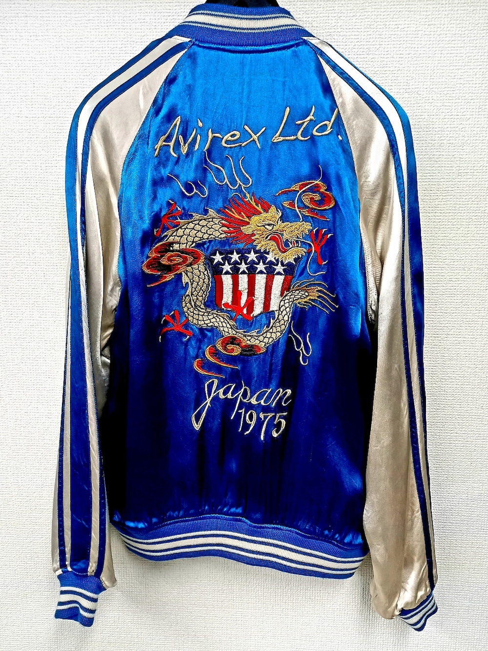 ブラック系のデニムパンツ、ブラック系のスニーカー、ブルー系のスカジャンを着用したメンズの冬コーディネートの5枚目の写真