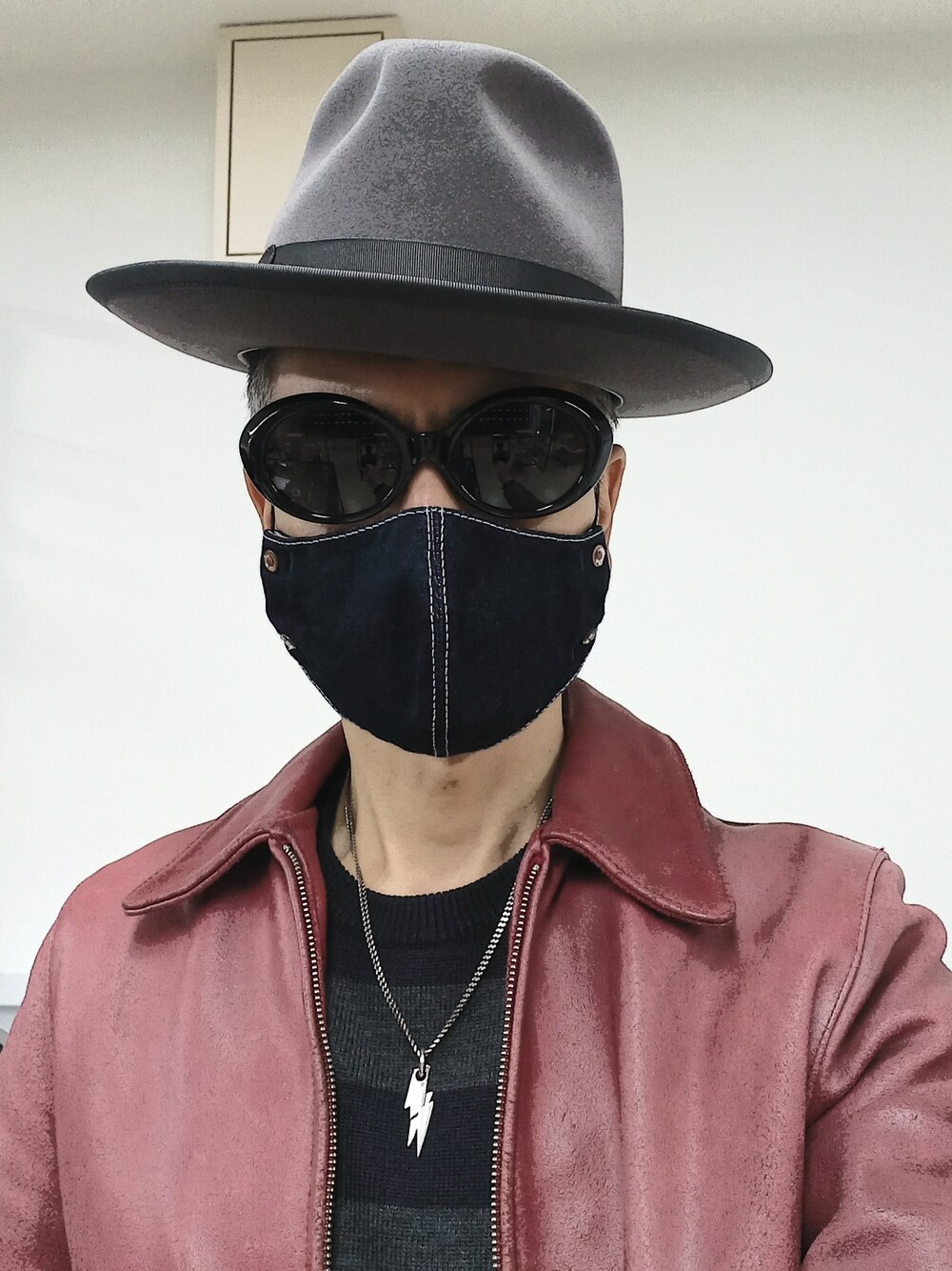 ブルー系のデニムパンツ、レッド系のブーツ、レッド系のライダースジャケットを着用したメンズの冬コーディネートの3枚目の写真