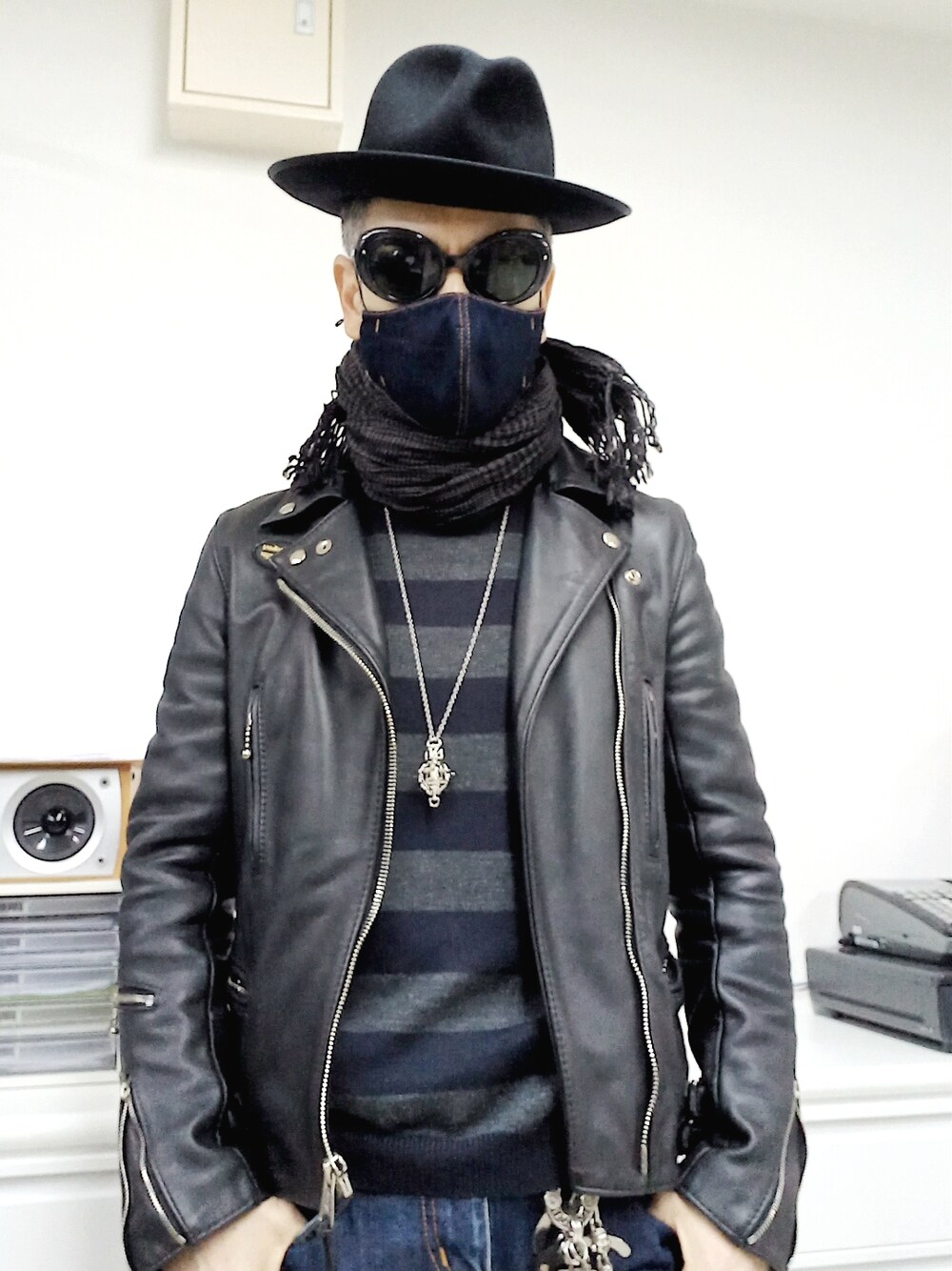 ブラック系のスニーカー、ブルー系のデニムパンツ、ブラック系のライダースジャケットを着用したメンズの春コーディネートの2枚目の写真