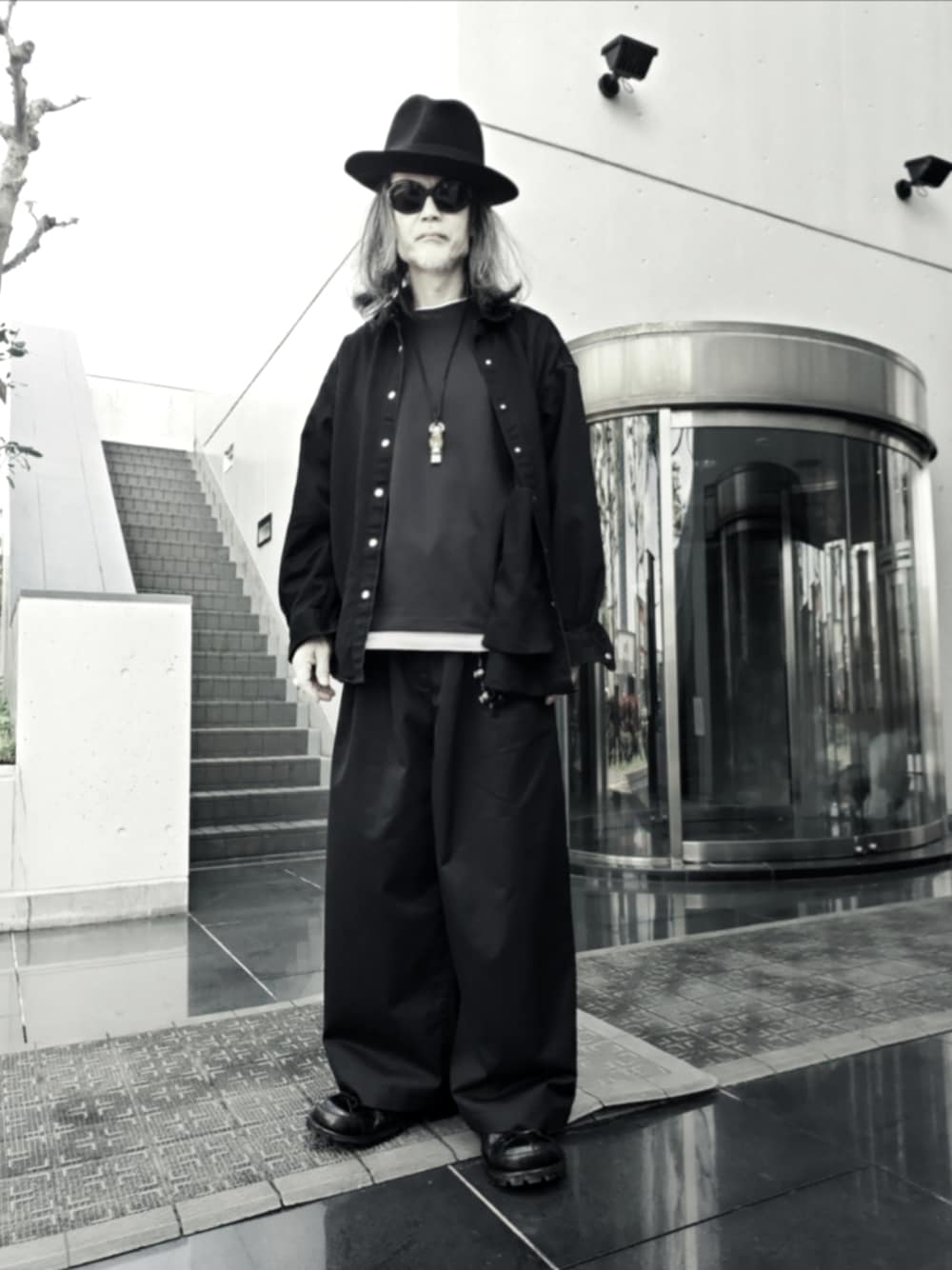 ブラック系のチノパンツ、ブラック系のTシャツ/カットソー、ブラック系のシャツ/ブラウスを着用したメンズの春コーディネートの1枚目の写真