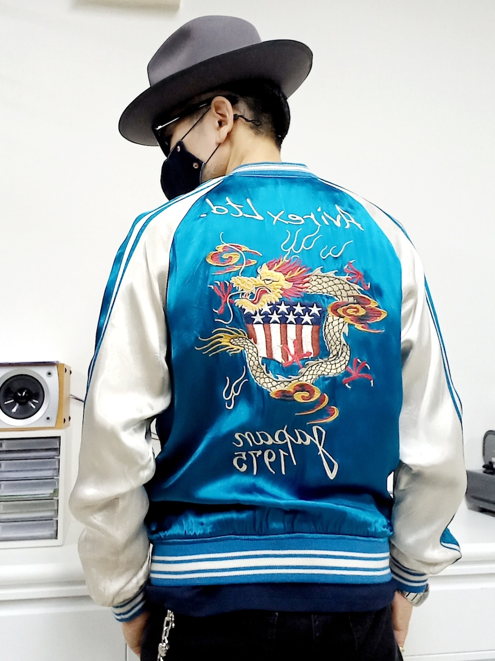 ブラック系のデニムパンツ、ブラック系のスニーカー、ブルー系のスカジャンを着用したメンズの冬コーディネートの3枚目の写真