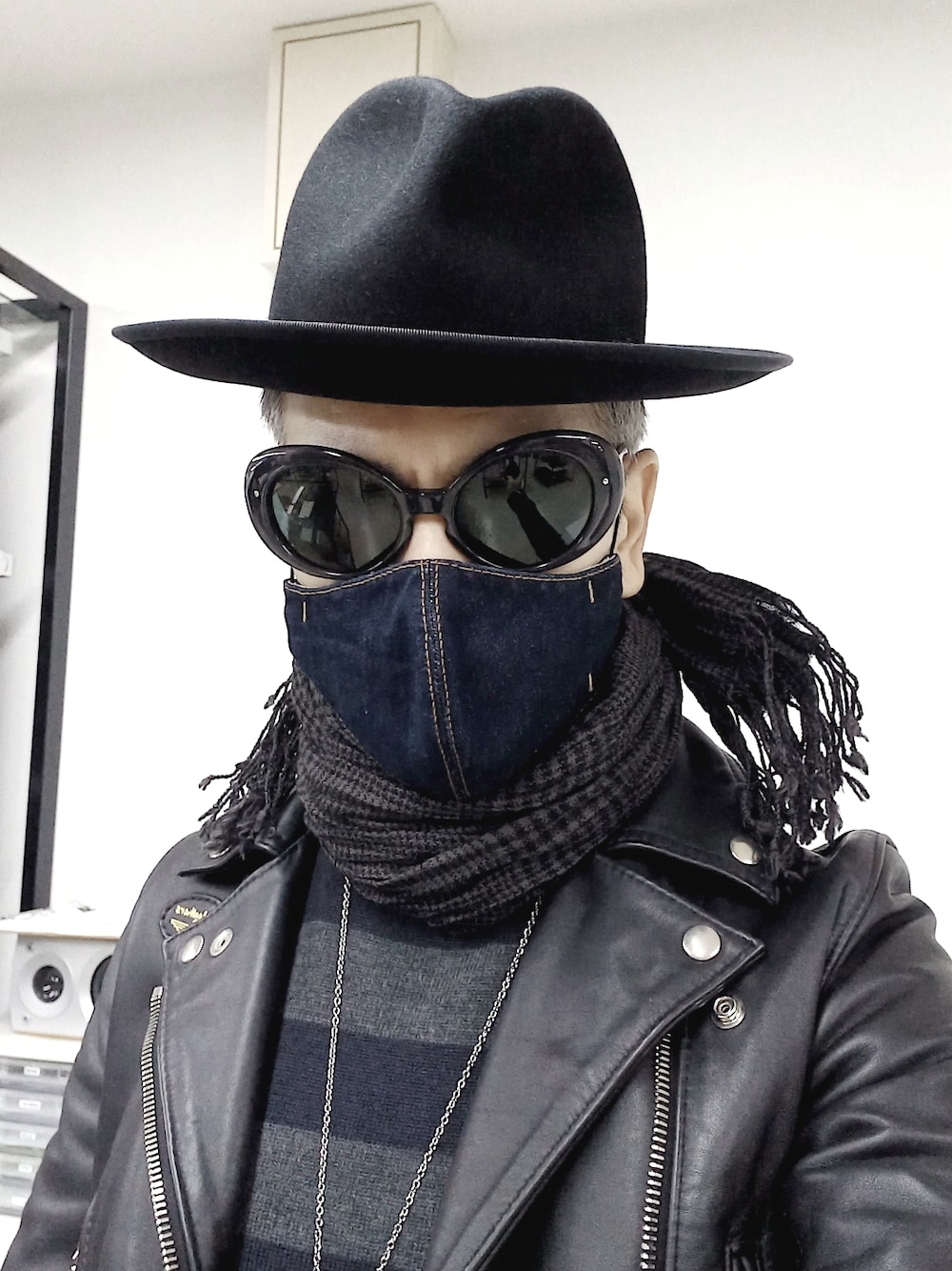 ブラック系のスニーカー、ブルー系のデニムパンツ、ブラック系のライダースジャケットを着用したメンズの春コーディネートの3枚目の写真