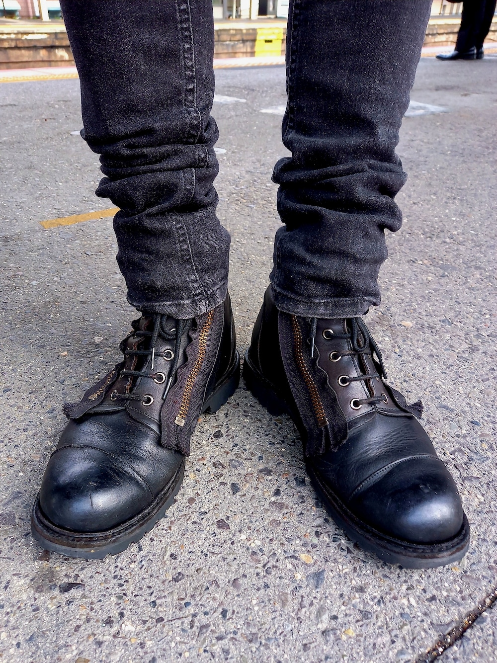 ブラック系のブーツ、ブラック系のデニムパンツ、ブラック系のライダースジャケットを着用したメンズの春コーディネートの5枚目の写真
