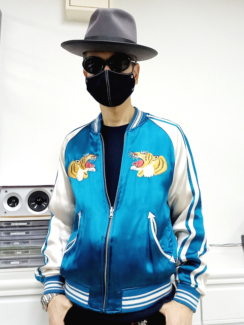 ブラック系のデニムパンツ、ブラック系のスニーカー、ブルー系のスカジャンを着用したメンズの冬コーディネートの2枚目の写真