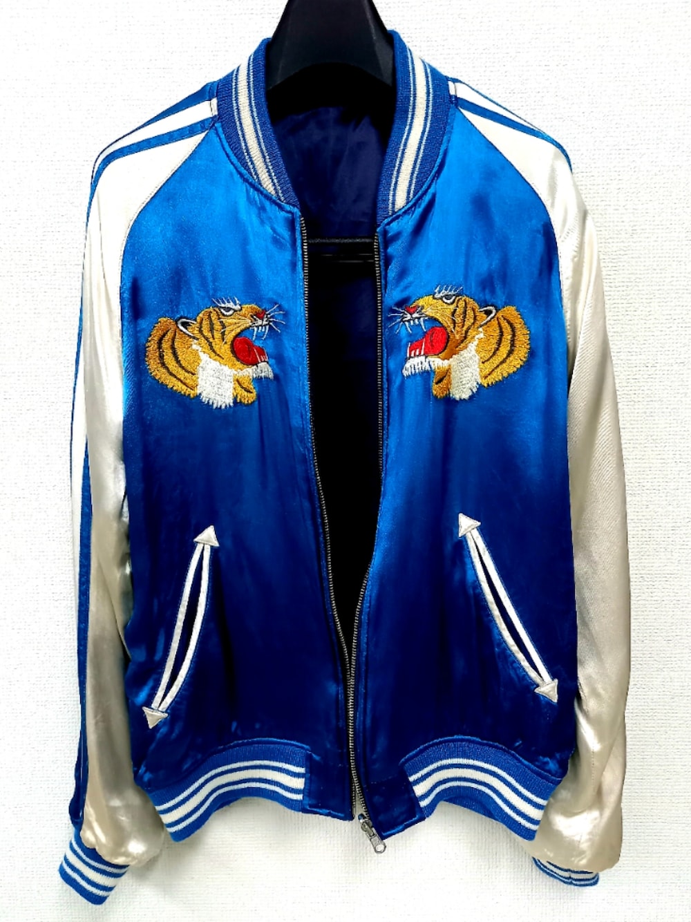 ブラック系のデニムパンツ、ブラック系のスニーカー、ブルー系のスカジャンを着用したメンズの冬コーディネートの4枚目の写真