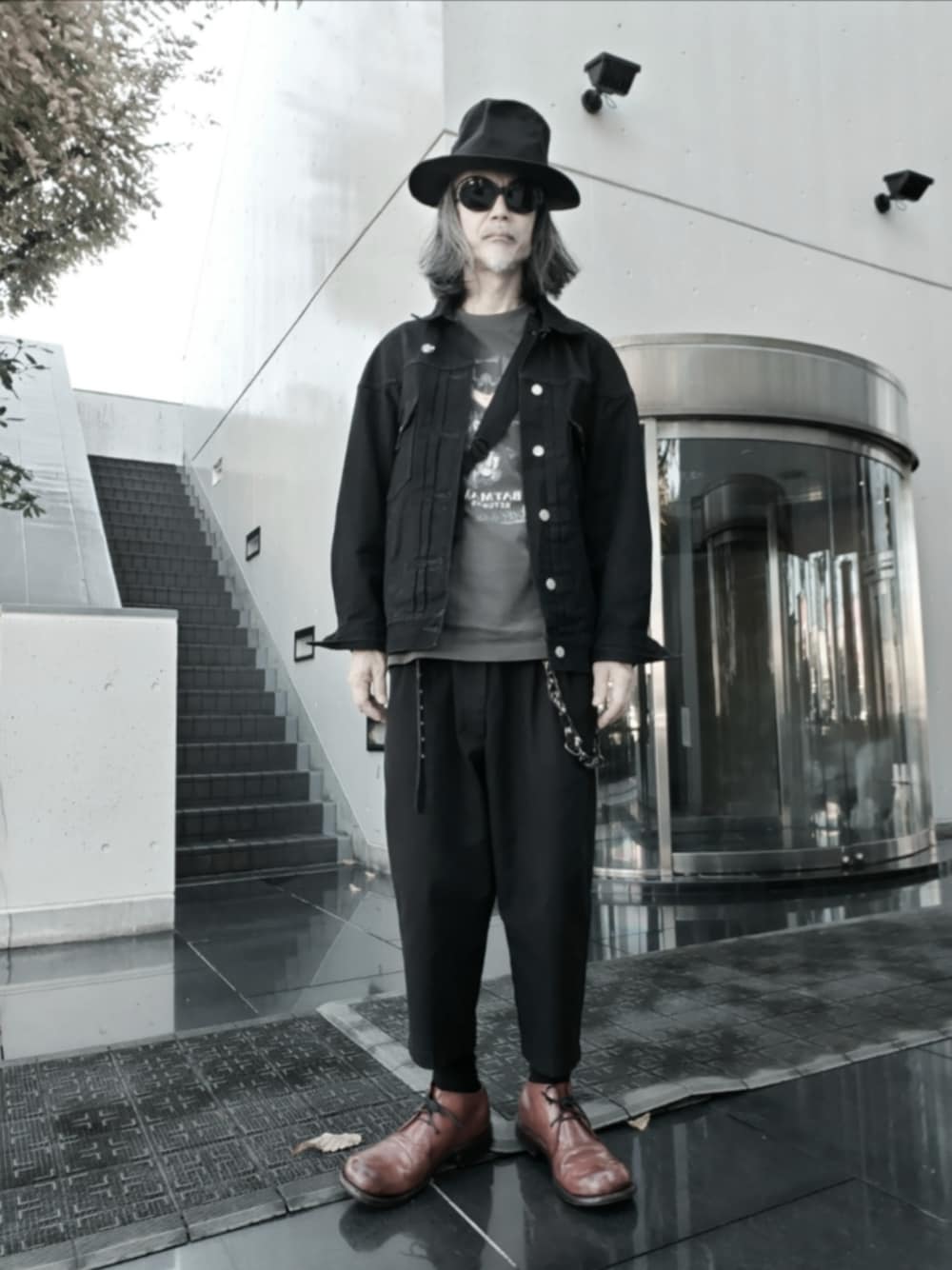 ブラック系のチノパンツ、グレー系のTシャツ/カットソー、ブラック系のデニムジャケットを着用したメンズの秋コーディネートの1枚目の写真