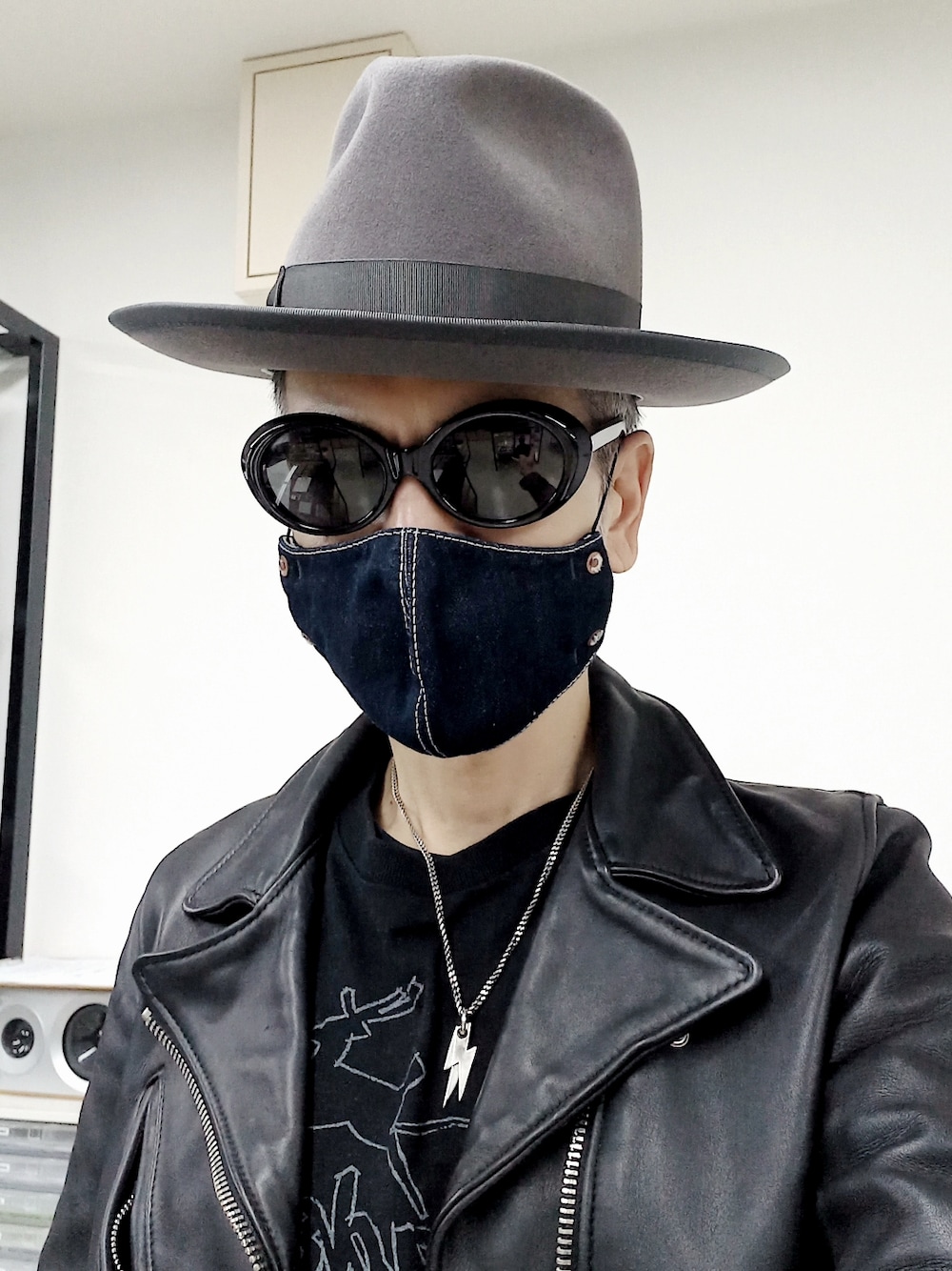 ブルー系のデニムパンツ、ブラック系のTシャツ/カットソー、ブラック系のライダースジャケットを着用したメンズの春コーディネートの3枚目の写真