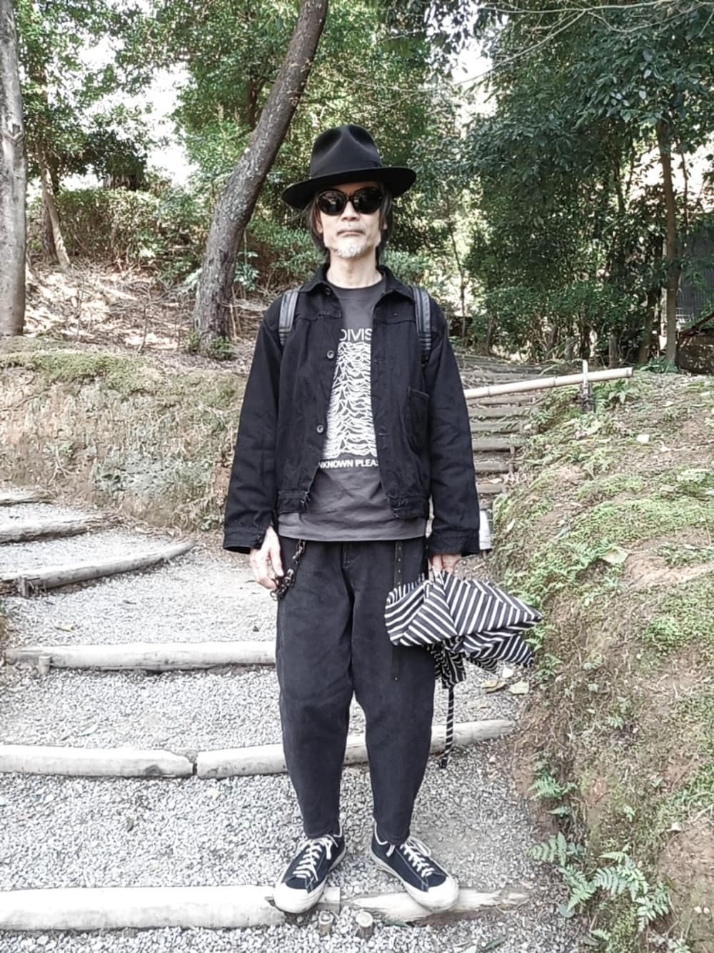 ブラック系のデニムジャケット、ブラック系のベスト、グレー系のTシャツ/カットソーを着用したメンズの春コーディネートの1枚目の写真