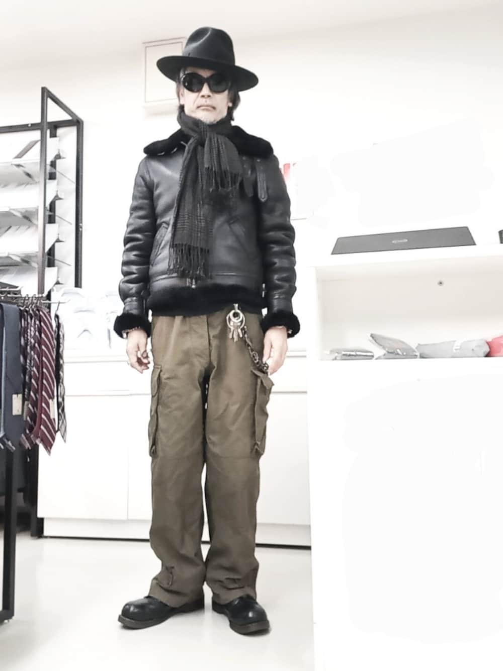 グリーン系のカーゴパンツ、ブラック系のブーツ、ブラック系のムートンコートを着用したメンズの冬コーディネートの1枚目の写真