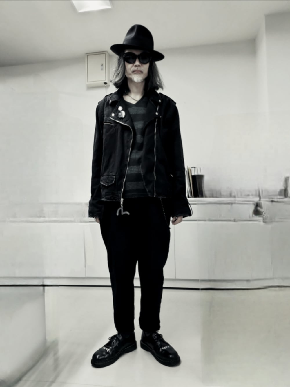 ブラック系のライダースジャケット、ブラック系のデニムパンツ、ブラック系のドレスシューズを着用したメンズの秋コーディネートの1枚目の写真