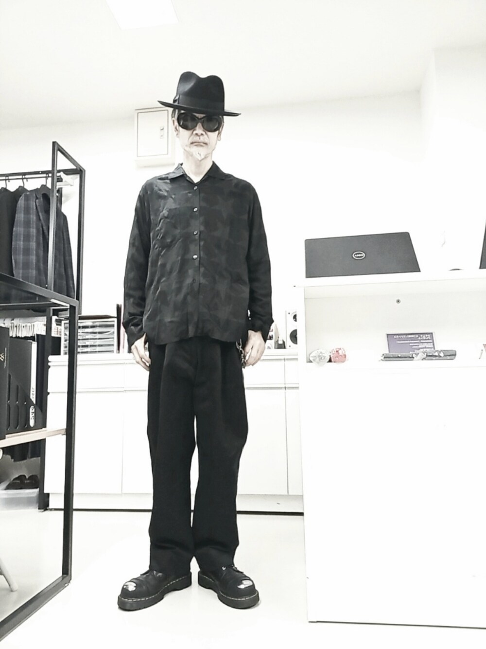 ブラック系のシャツ/ブラウス、ブラック系のチノパンツ、ブラック系のドレスシューズを着用したメンズの春コーディネートの1枚目の写真