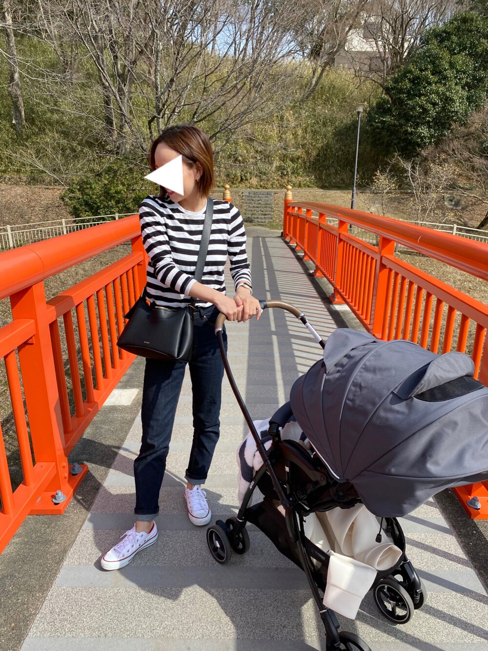 ホワイト系のTシャツ/カットソー、ホワイト系のスニーカー、ブルー系のデニムパンツを着用したレディースの春コーディネートの1枚目の写真