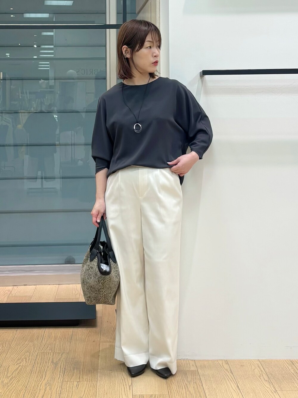 グレー系のシャツ/ブラウス、ホワイト系のその他パンツ、ブラック系のトートバッグを着用したレディースの春コーディネートの1枚目の写真
