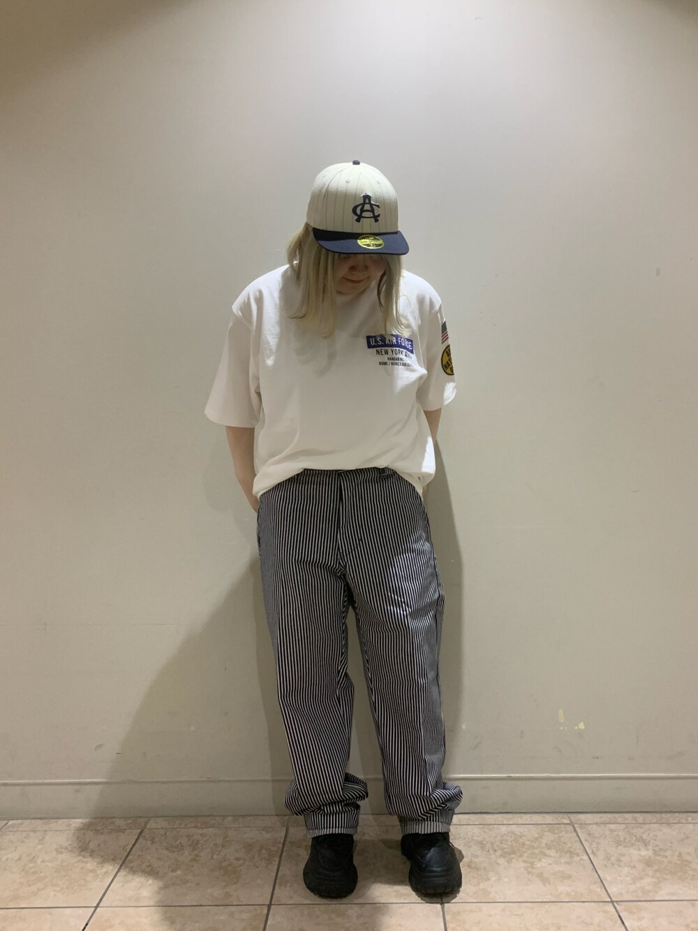 ホワイト系のTシャツ/カットソー、その他のチノパンツ、ホワイト系のキャップを着用したレディースの春コーディネートの1枚目の写真