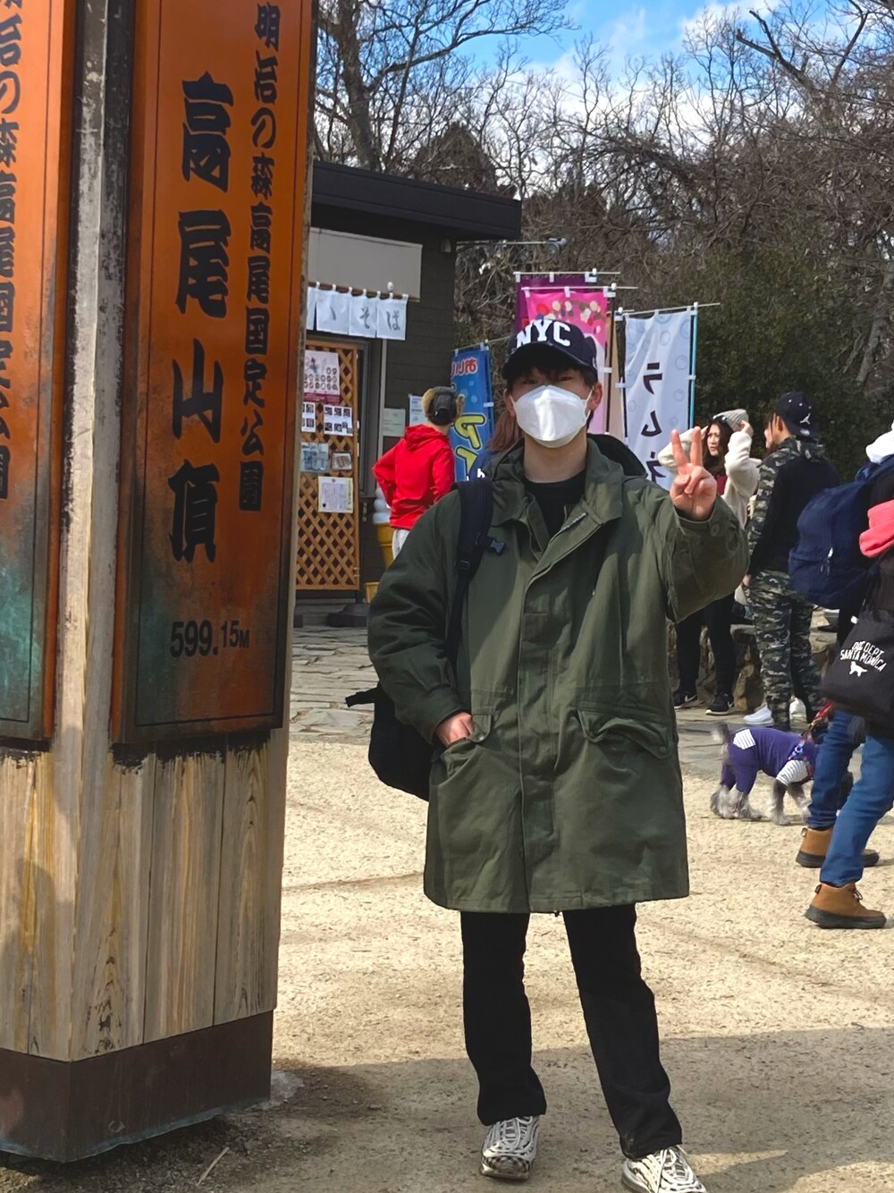 ブラック系のデニムパンツ、ホワイト系のスニーカー、グリーン系のモッズコートを着用したメンズの冬コーディネートの1枚目の写真