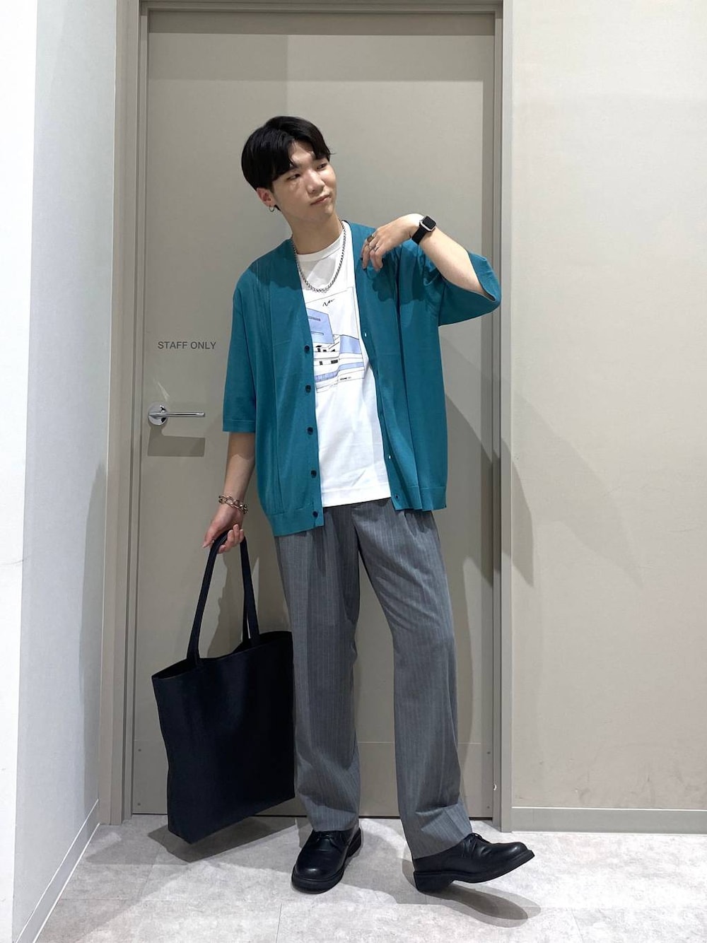 ブラック系のトートバッグ、グレー系のスラックス、ホワイト系のTシャツ/カットソーを着用したメンズの夏コーディネートの1枚目の写真