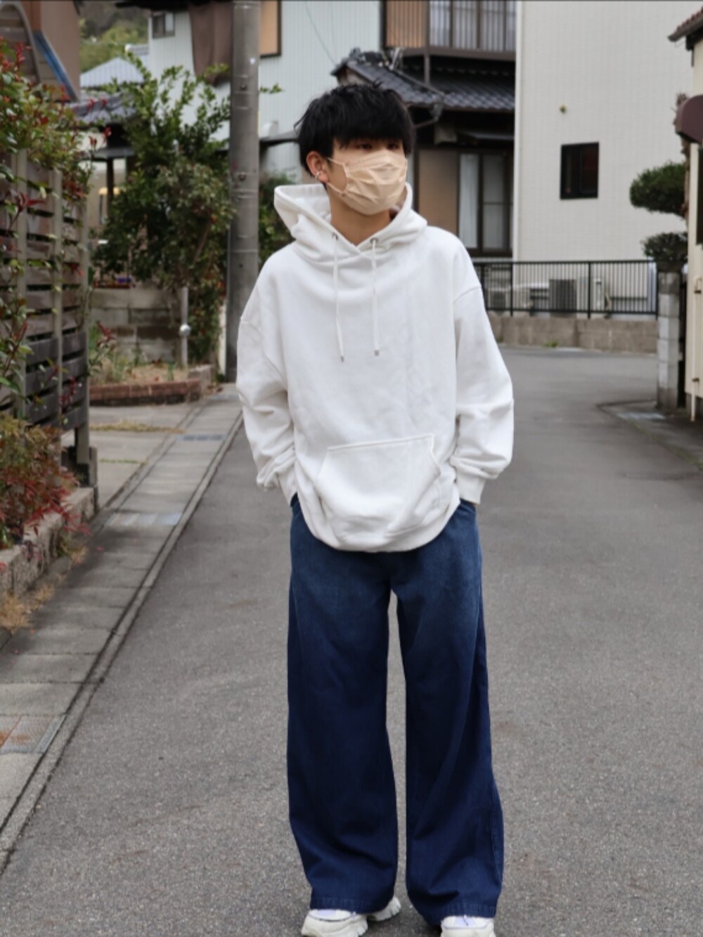 ホワイト系のパーカー、ブルー系のデニムパンツ、ホワイト系のスニーカーを着用したメンズの春コーディネートの1枚目の写真