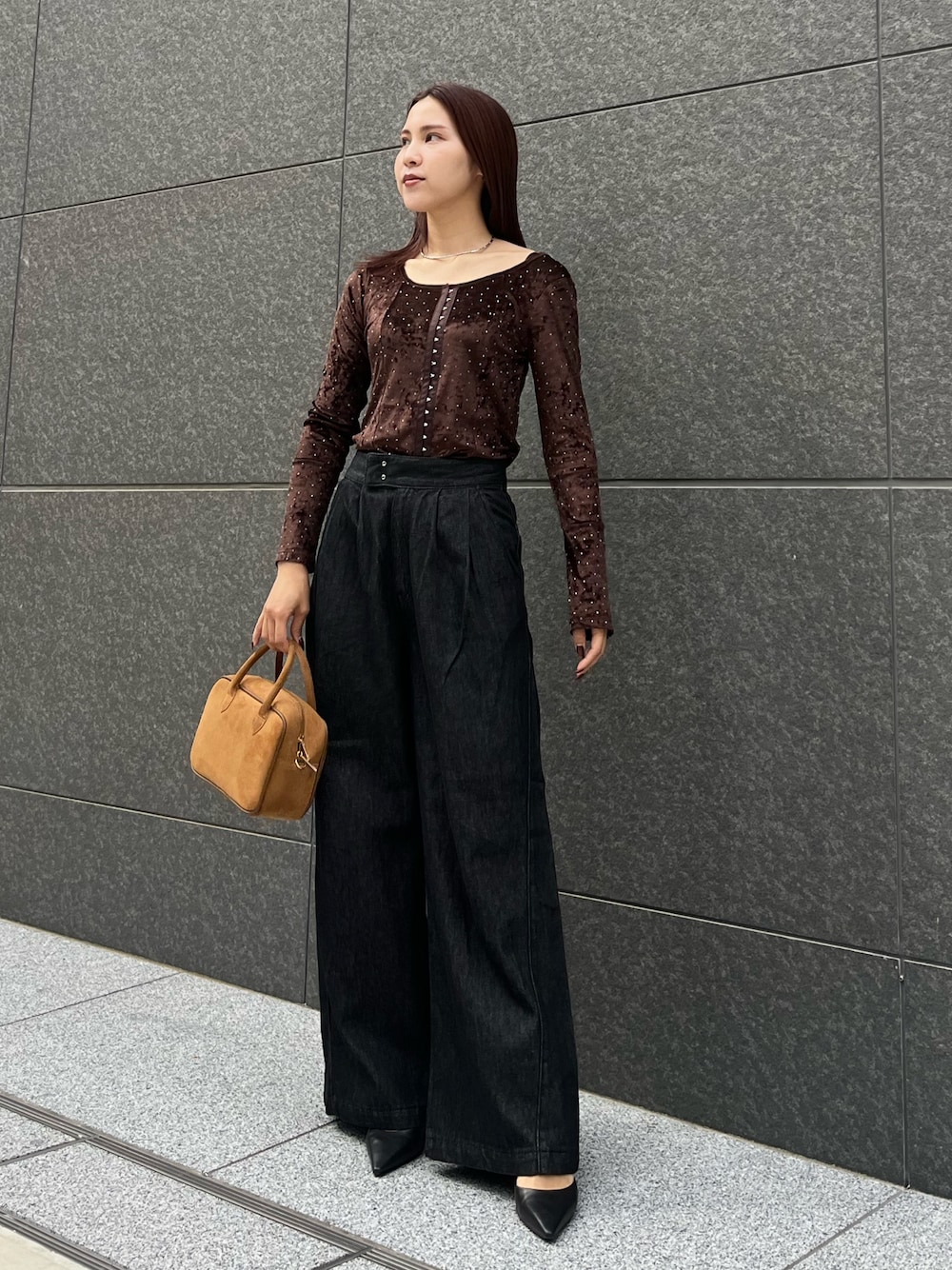 ブラック系のデニムパンツ、ブラウン系のハンドバッグ、ブラウン系のTシャツ/カットソーを着用したレディースの秋コーディネートの1枚目の写真