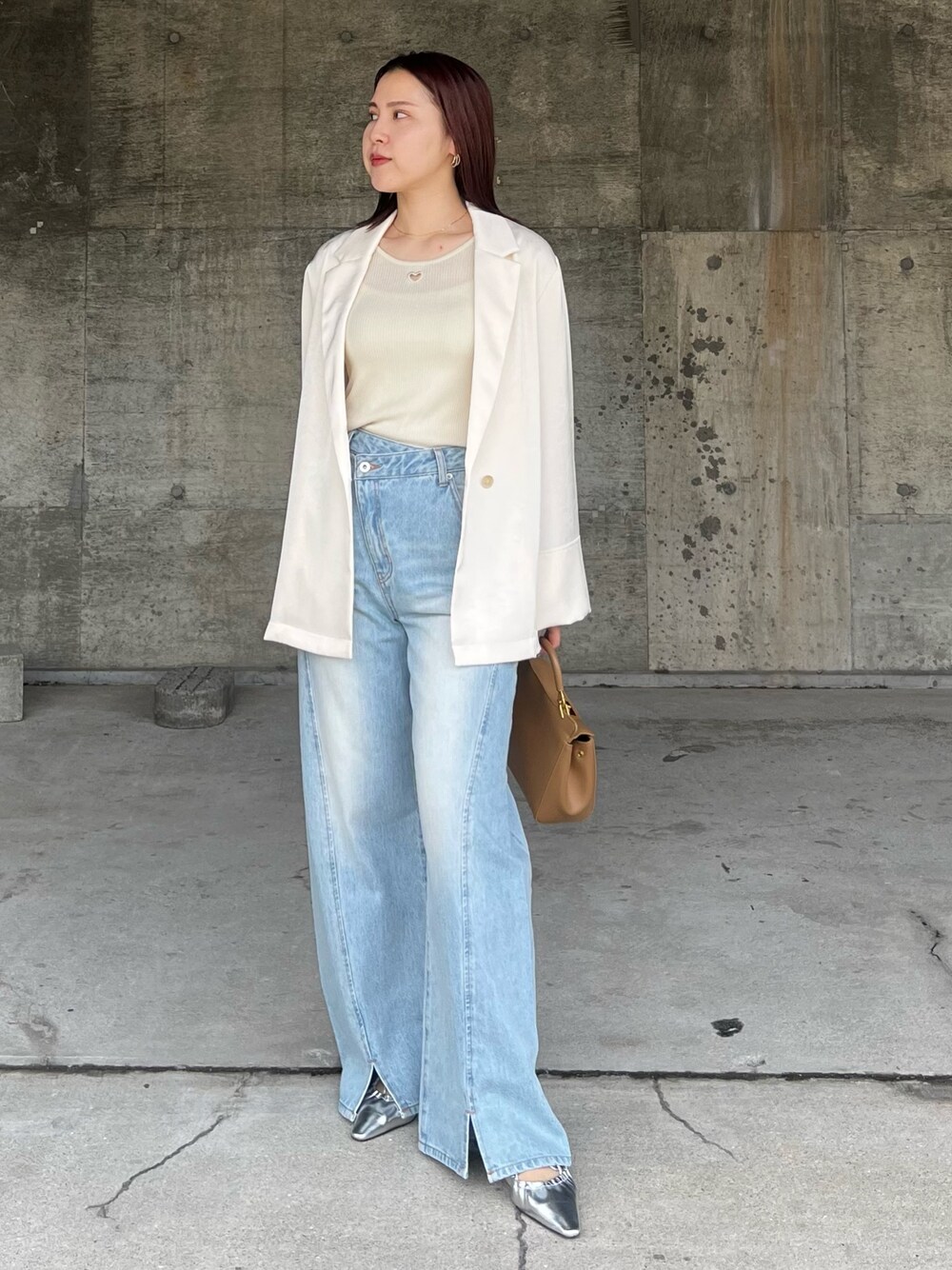 ブルー系のデニムパンツ、シルバー系のサンダル、ブラウン系のハンドバッグを着用したレディースの春コーディネートの1枚目の写真